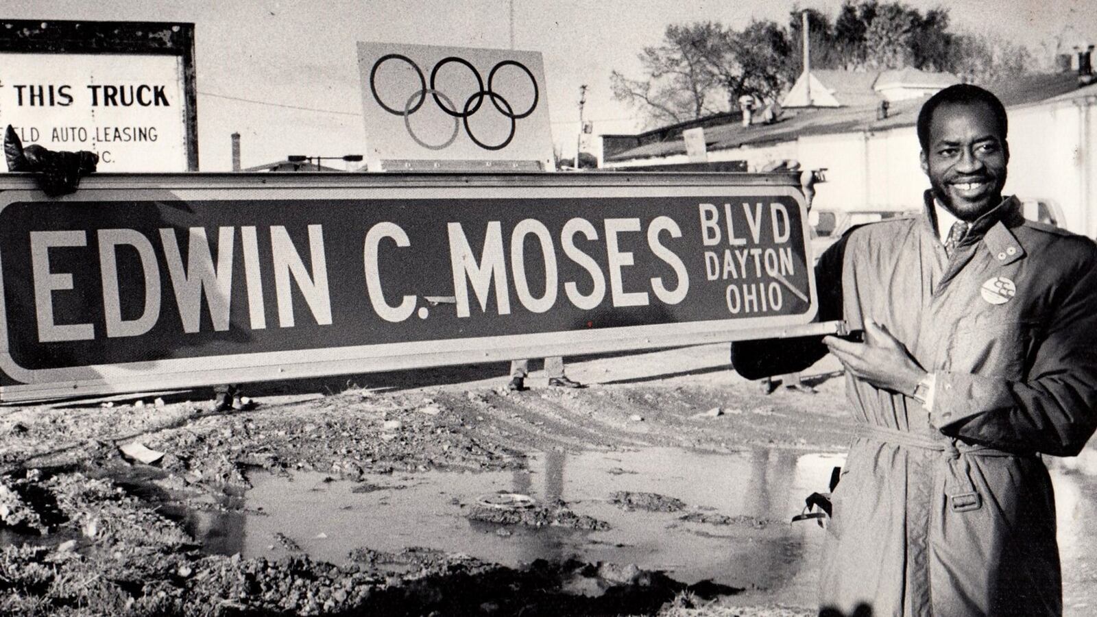 Edwin Moses holds up an Edwin C. Moses Blvd. street sign for photographers during a ceremony renaming the street to honor the Olympic gold medal winner in 1984. DAYTON DAILY NEWS ARCHIVE