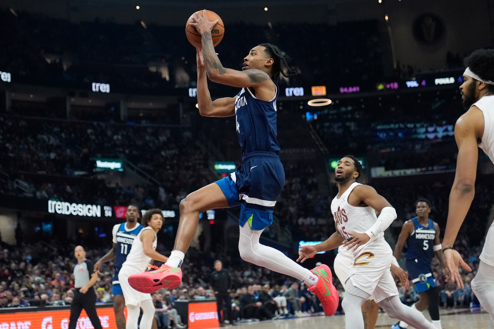 Minnesota Timberwolves guard Rob Dillingham, left, goes to the basket in front of Cleveland Cavaliers guard Donovan Mitchell, right, in the first half of an NBA basketball game Monday, Feb. 10, 2025, in Cleveland. (AP Photo/Sue Ogrocki)