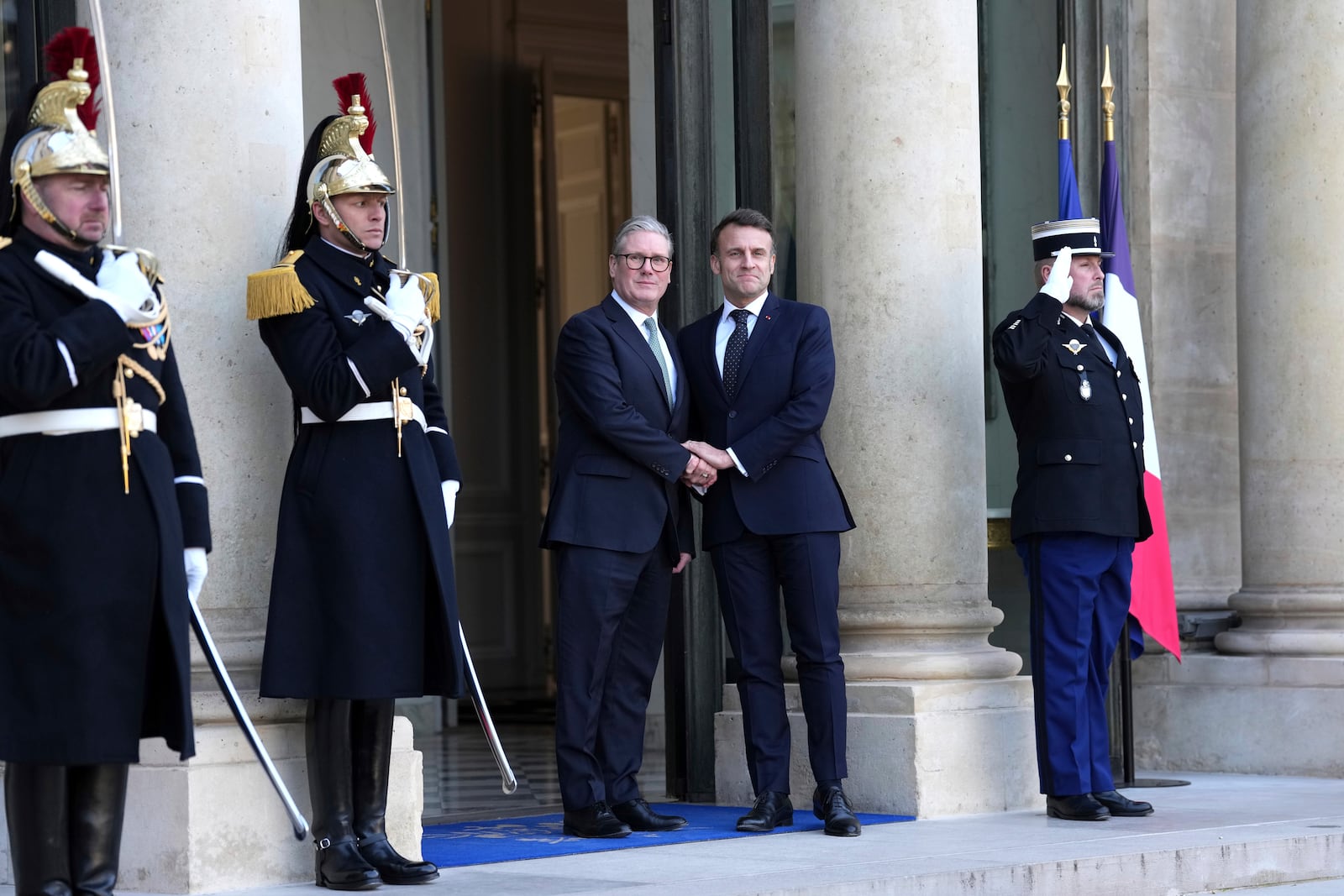 French President Emmanuel Macron, center right, greets Britain's Prime Minister Keir Stammer as he arrives for an informal meeting of leaders from key European Union nations and the United Kingdom at the Elysee Palace in Paris, Monday, Feb. 17, 2025. (AP Photo/Aurelien Morissard)