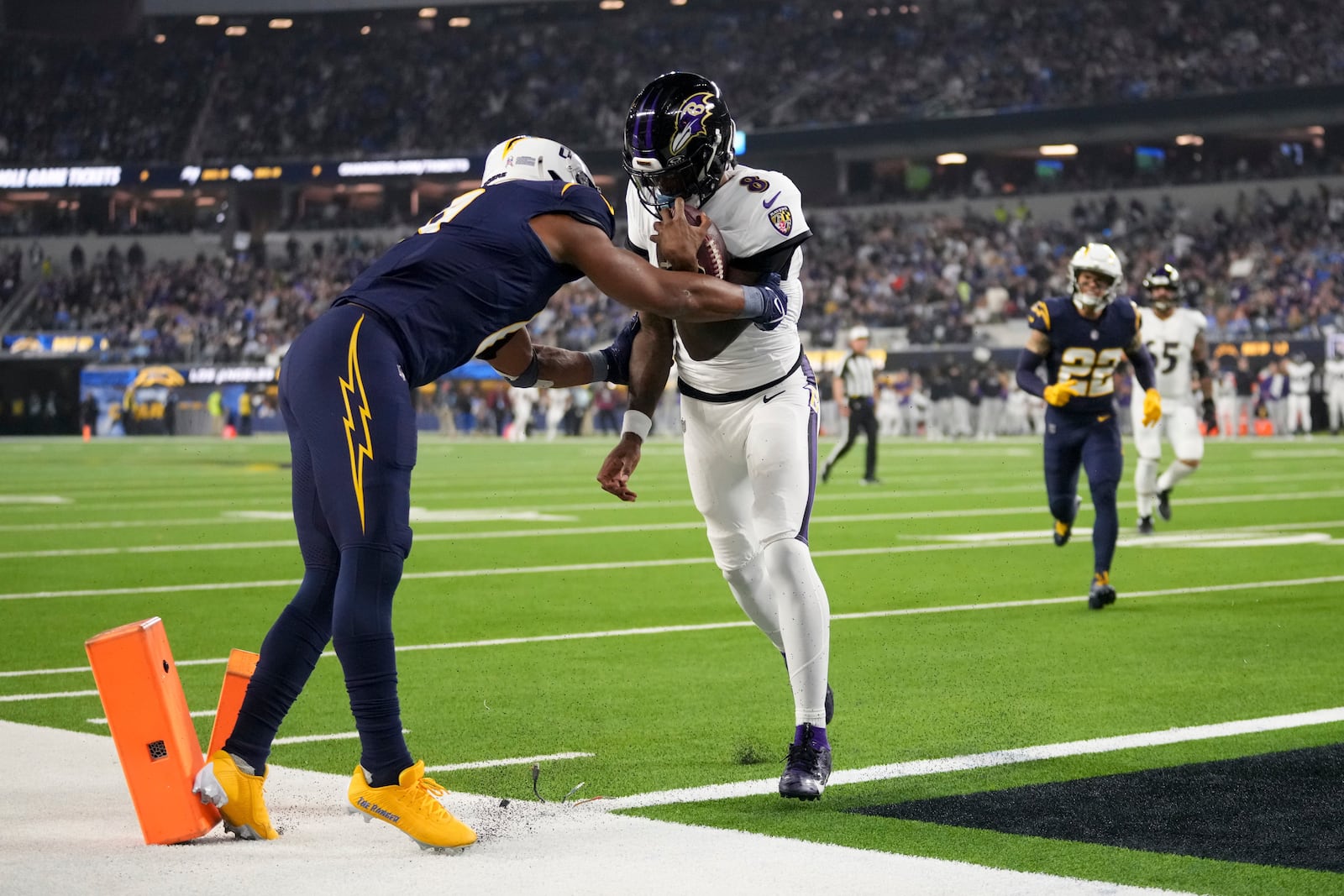 Baltimore Ravens quarterback Lamar Jackson (8) scores a rushing touchdown as Los Angeles Chargers linebacker Daiyan Henley attempts a tackle during the first half of an NFL football game Monday, Nov. 25, 2024, in Inglewood, Calif. (AP Photo/Eric Thayer)