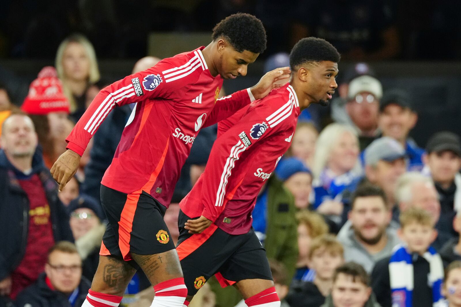 Manchester United's Marcus Rashford, left, is congratulated by Amad Diallo after scoring his side's opening goal during the English Premier League soccer match between Ipswich Town and Manchester United at Portman Road stadium in Ipswich, England, Sunday, Nov. 24, 2024. (AP Photo/Dave Shopland)