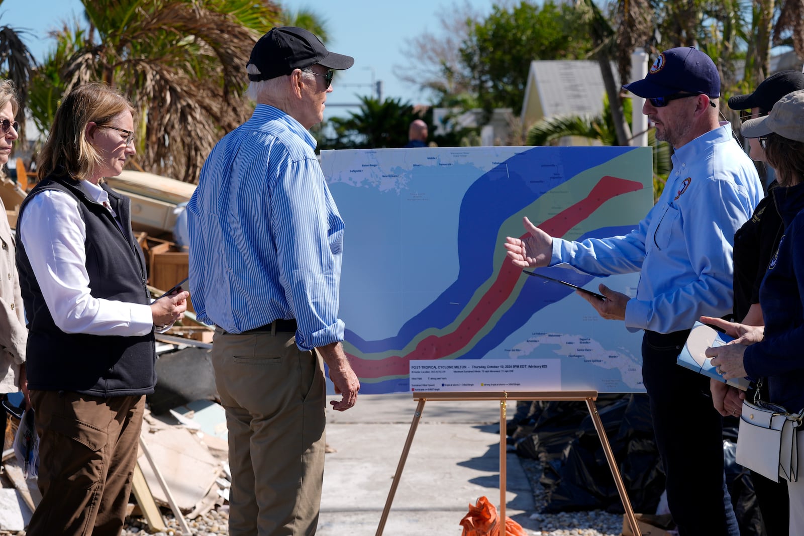 President Joe Biden, second left, is briefed by federal, state, and local officials in St. Pete Beach, Fla., following an aerial tour of the Hurricane Milton affected areas, Sunday, Oct. 13, 2024. (AP Photo/Manuel Balce Ceneta)