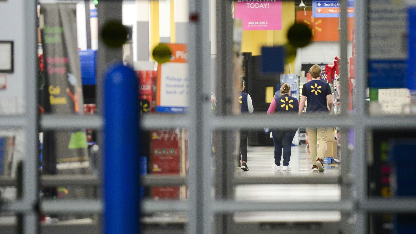 Walmart employees walk down an aisle in a Highlands Ranch, Colo., store Nov. 29, 2019.