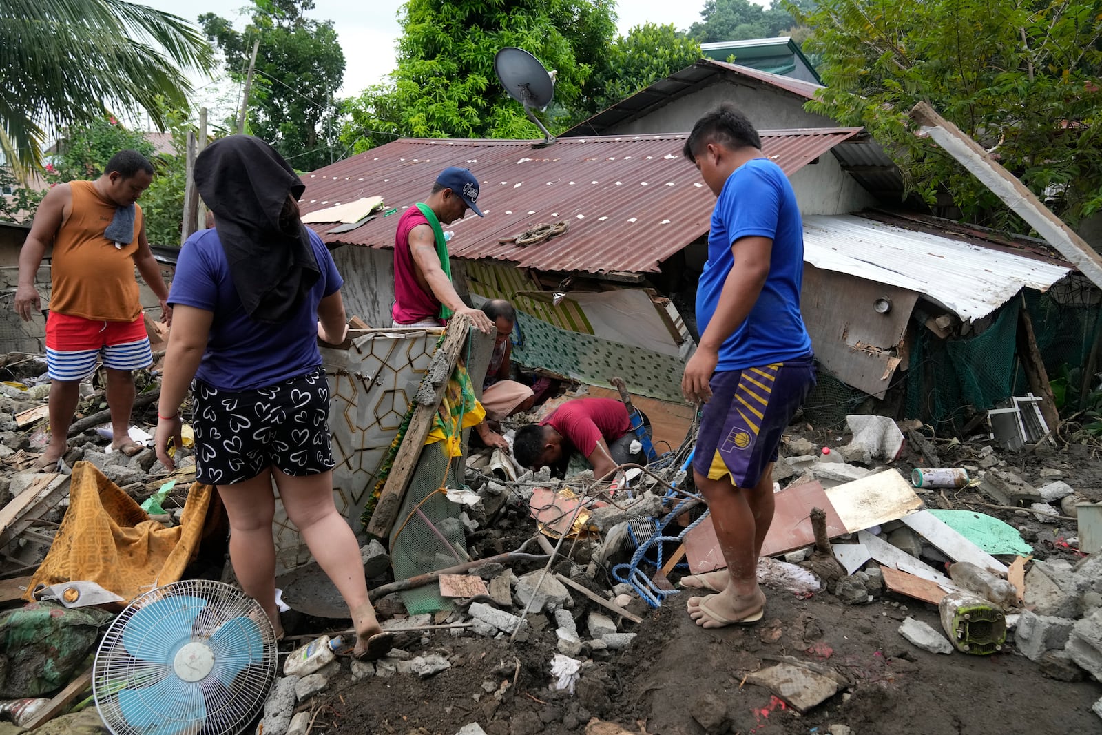 Residents try to recover personal belongings from their damaged home after a landslide triggered by Tropical Storm Trami recently struck Talisay, Batangas province, Philippines, Saturday, Oct. 26, 2024. (AP Photo/Aaron Favila)