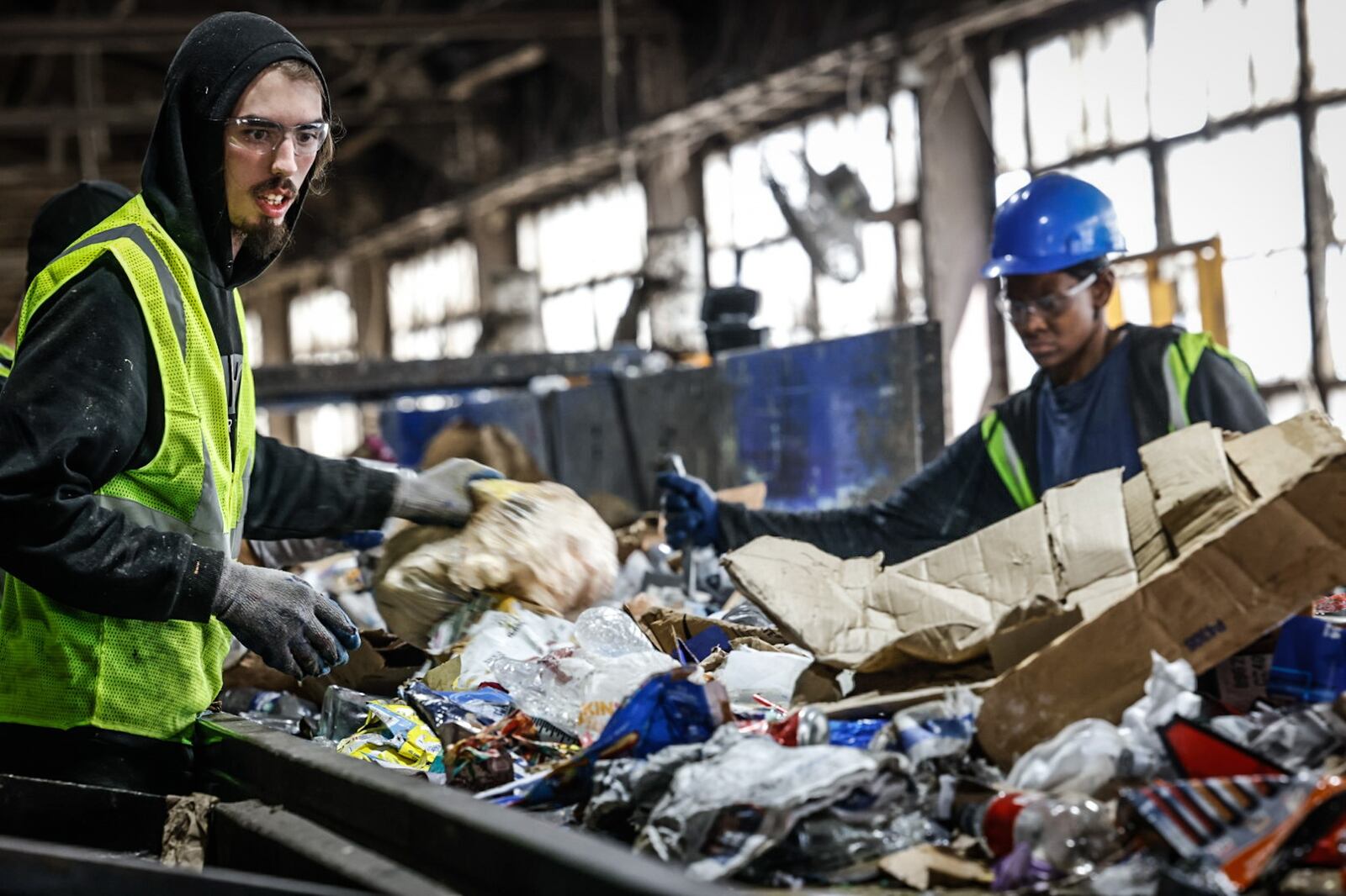 Rumpke recycling sorters Mason Bellmey, left and Tyler Watson pullout trash from cardboard which is recycled. Rumpke recycles 17 to 20 toms of cardboard an hour. JIM NOELKER/STAFF