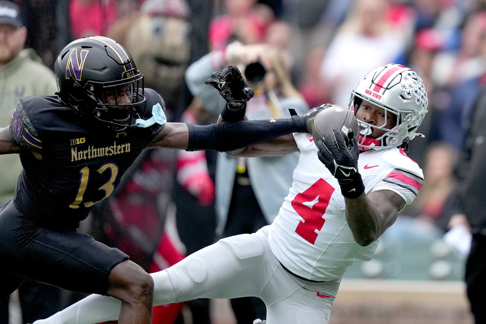 Ohio State wide receiver Jeremiah Smith catches a touchdown pass as Northwestern's Josh Fussell defends during the first half of an NCAA college football game at Wrigley Field on Saturday, Nov. 16, 2024, in Chicago. The catch was over turned after video review. (AP Photo/Charles Rex Arbogast)