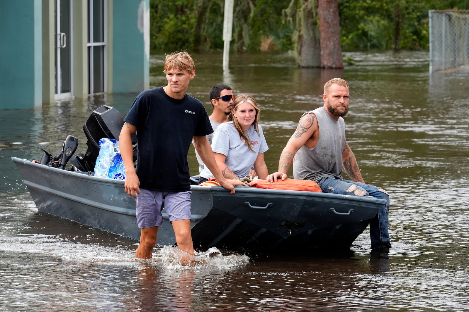 Residents along the Alafia river use a boat as transportation through floodwaters caused by Hurricane Milton Friday, Oct. 11, 2024, in Lithia, Fla. (AP Photo/Chris O'Meara)