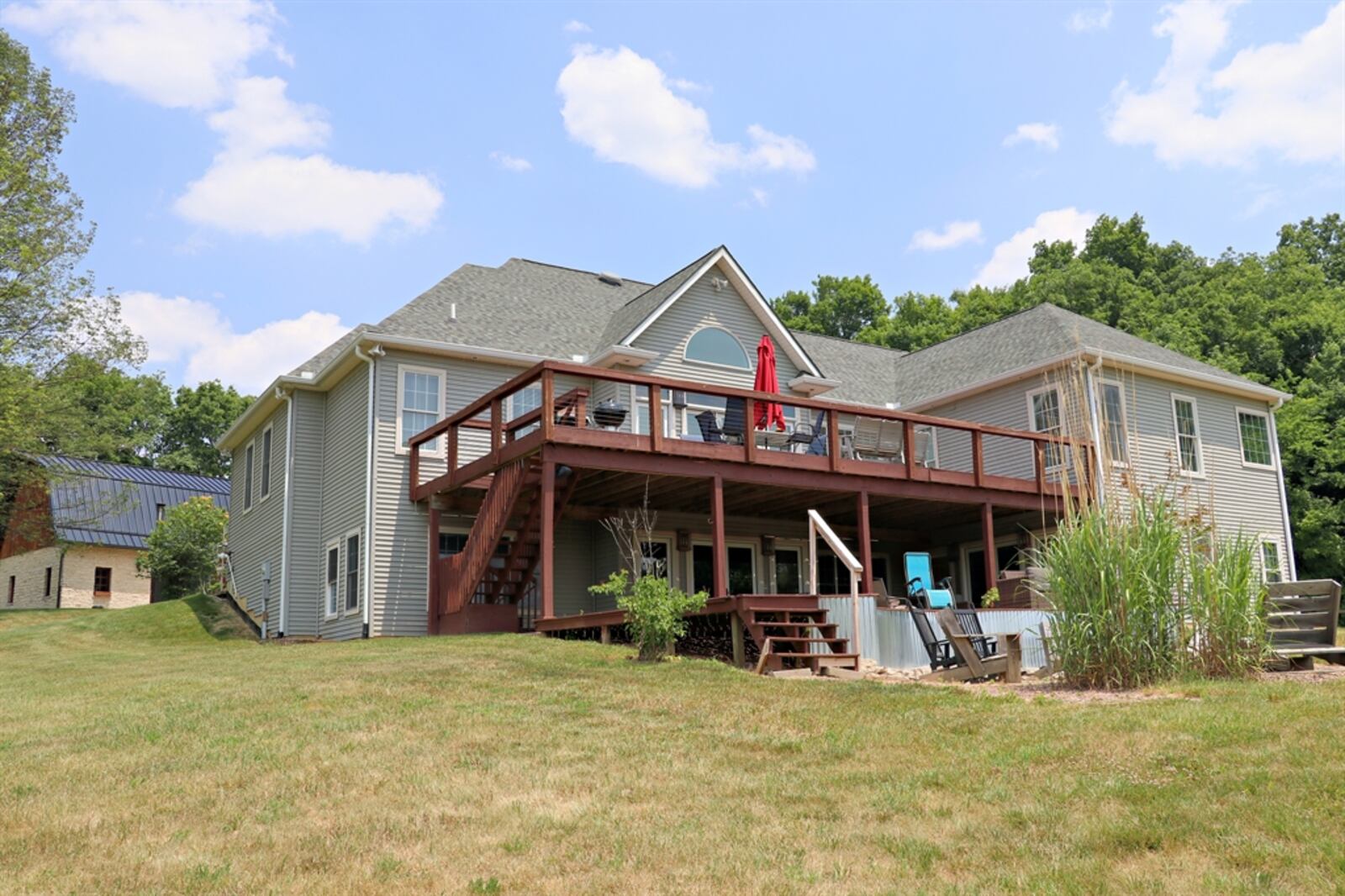 Double doors open out to a covered concrete patio that leads down to a fire pit area.