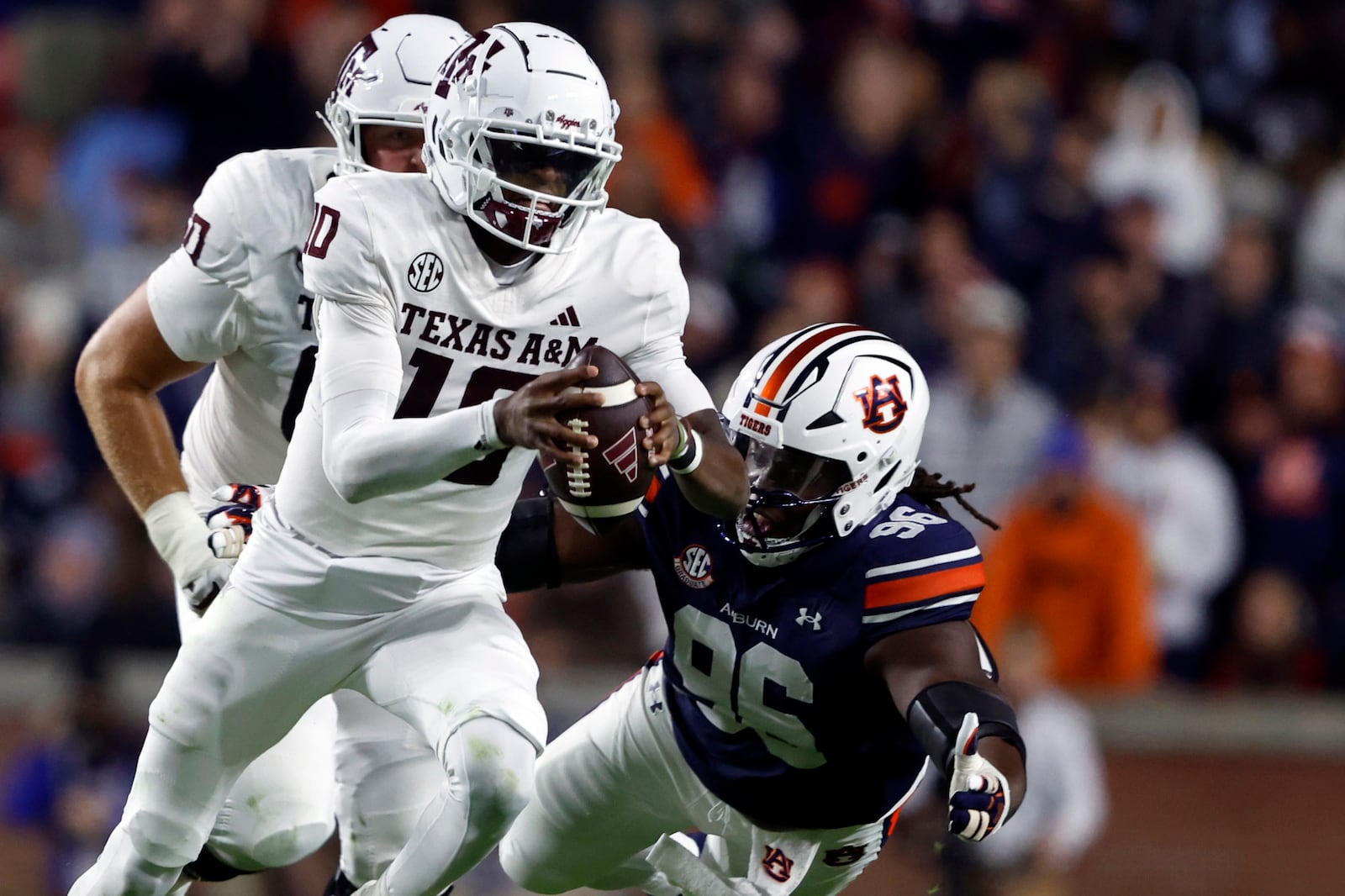 Texas A&M quarterback Marcel Reed (10) is tackled by Auburn defensive lineman Philip Blidi (96) as he scrambles for yardage during the first half of an NCAA college football game, Saturday, Nov. 23, 2024, in Auburn, Ala. (AP Photo/Butch Dill)