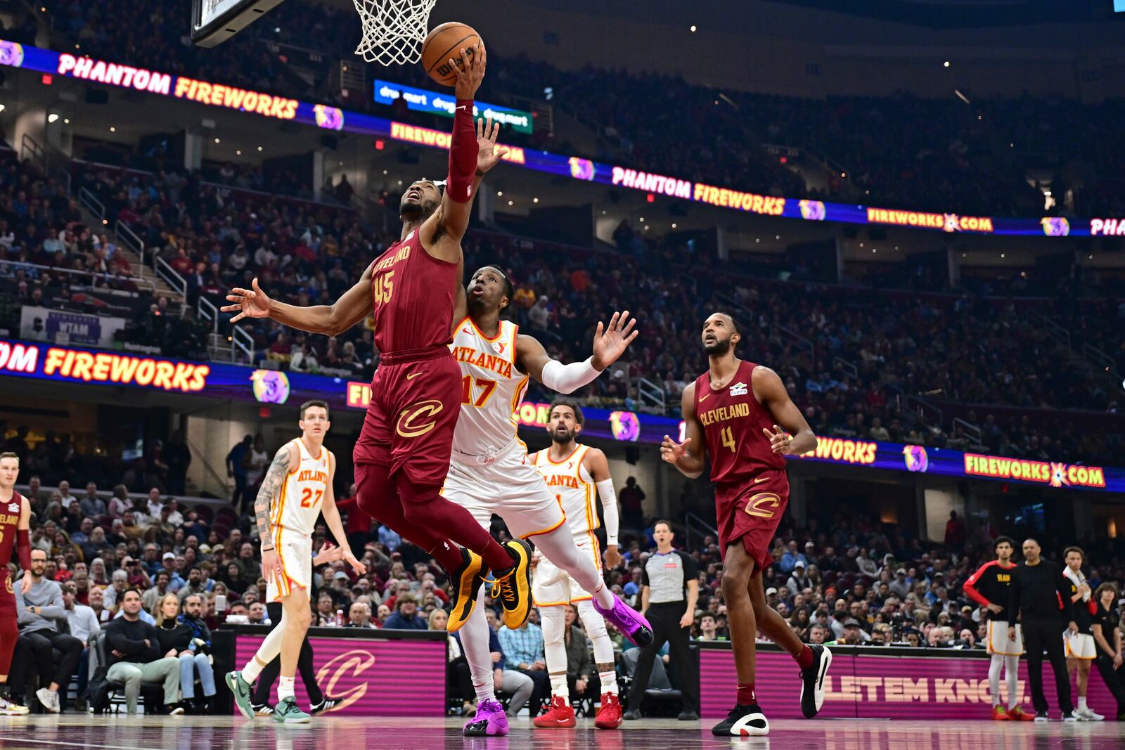 Cleveland Cavaliers guard Donovan Mitchell (45) goes to the basket against Atlanta Hawks forward Onyeka Okongwu (17) in the first half of an NBA basketball game, Thursday, Jan. 30, 2025, in Cleveland. (AP Photo/David Dermer)