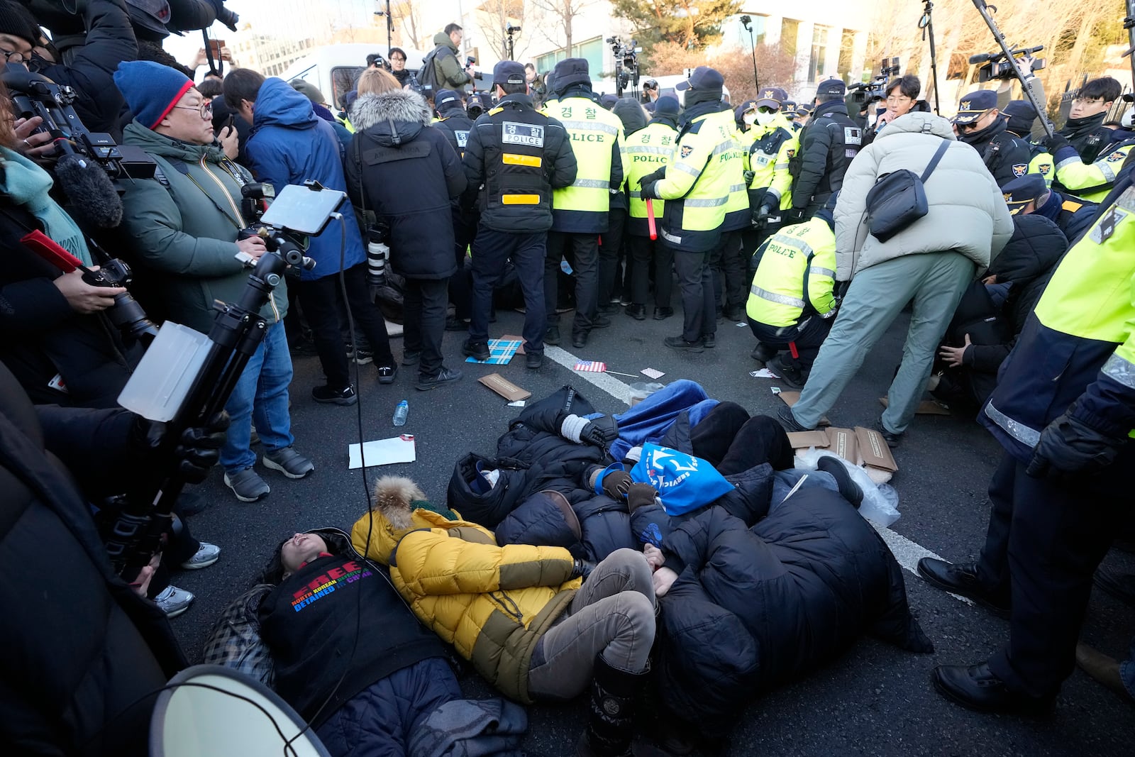 Supporters of impeached South Korean President Yoon Suk Yeol lie down on the ground as Yoon faces potential arrest after a court on Tuesday approved a warrant for his arrest, near the presidential residence in Seoul, South Korea, Thursday, Jan. 2, 2025. (AP Photo/Ahn Young-joon)