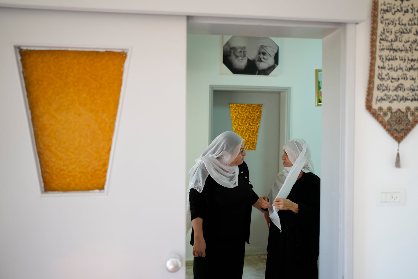 Samar Safadi, left, talks with her mother after speaking by phone with her sister, Sawsan, who lives inside the buffer zone near the "Alpha Line" that separates the Israeli-controlled Golan Heights from Syria, in the town of Majdal Shams, Wednesday, Dec. 18, 2024. (AP Photo/Matias Delacroix)