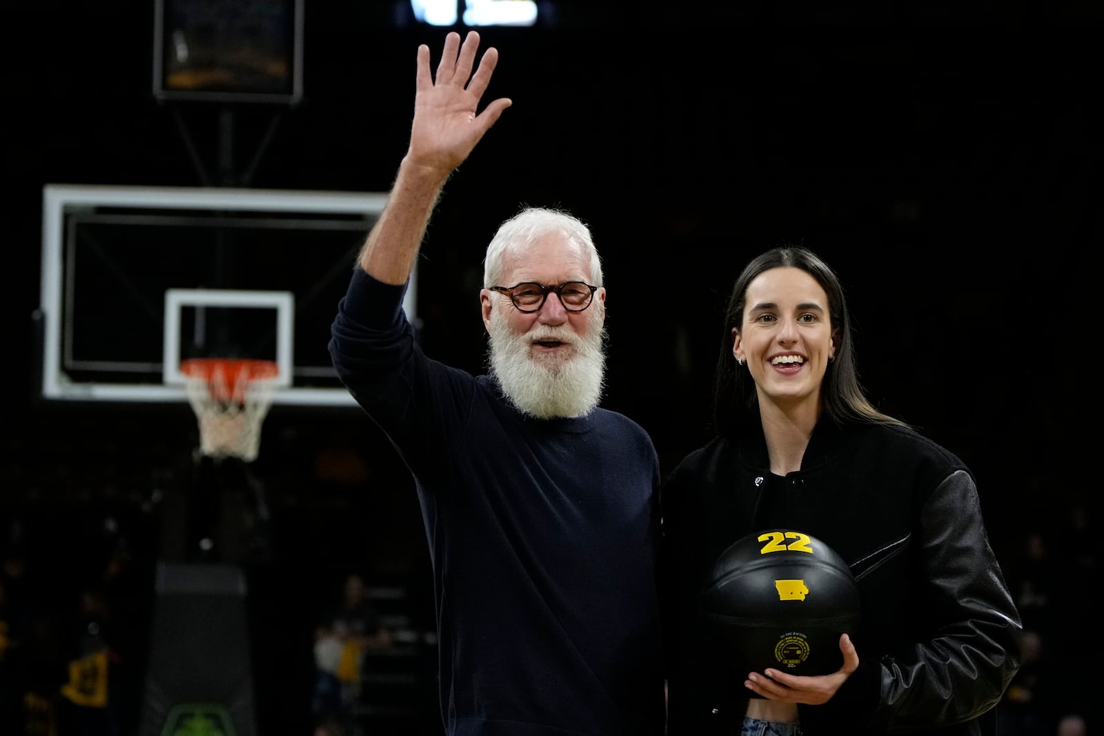 Former Iowa guard and current Indiana Fever WNBA player Caitlin Clark, right, stands with David Letterman, left, during her jersey retirement ceremony after an NCAA college basketball game between Iowa and Southern California, Sunday, Feb. 2, 2025, in Iowa City, Iowa. (AP Photo/Charlie Neibergall)