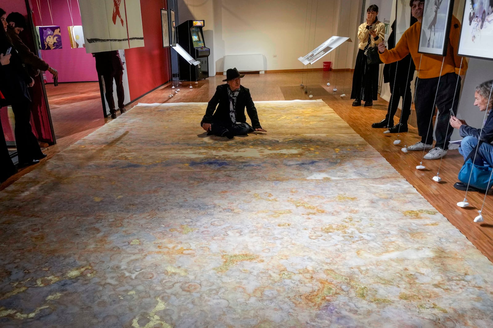 Artist Yoshitaka Amano sits on one of his creations during the press preview of the exhibition "Amano Corpus Animae", celebrating his 50-year-long career, at the Fabbrica del Vapore, in Milan, Italy, Tuesday, Nov. 12, 2024. (AP Photo/Luca Bruno)