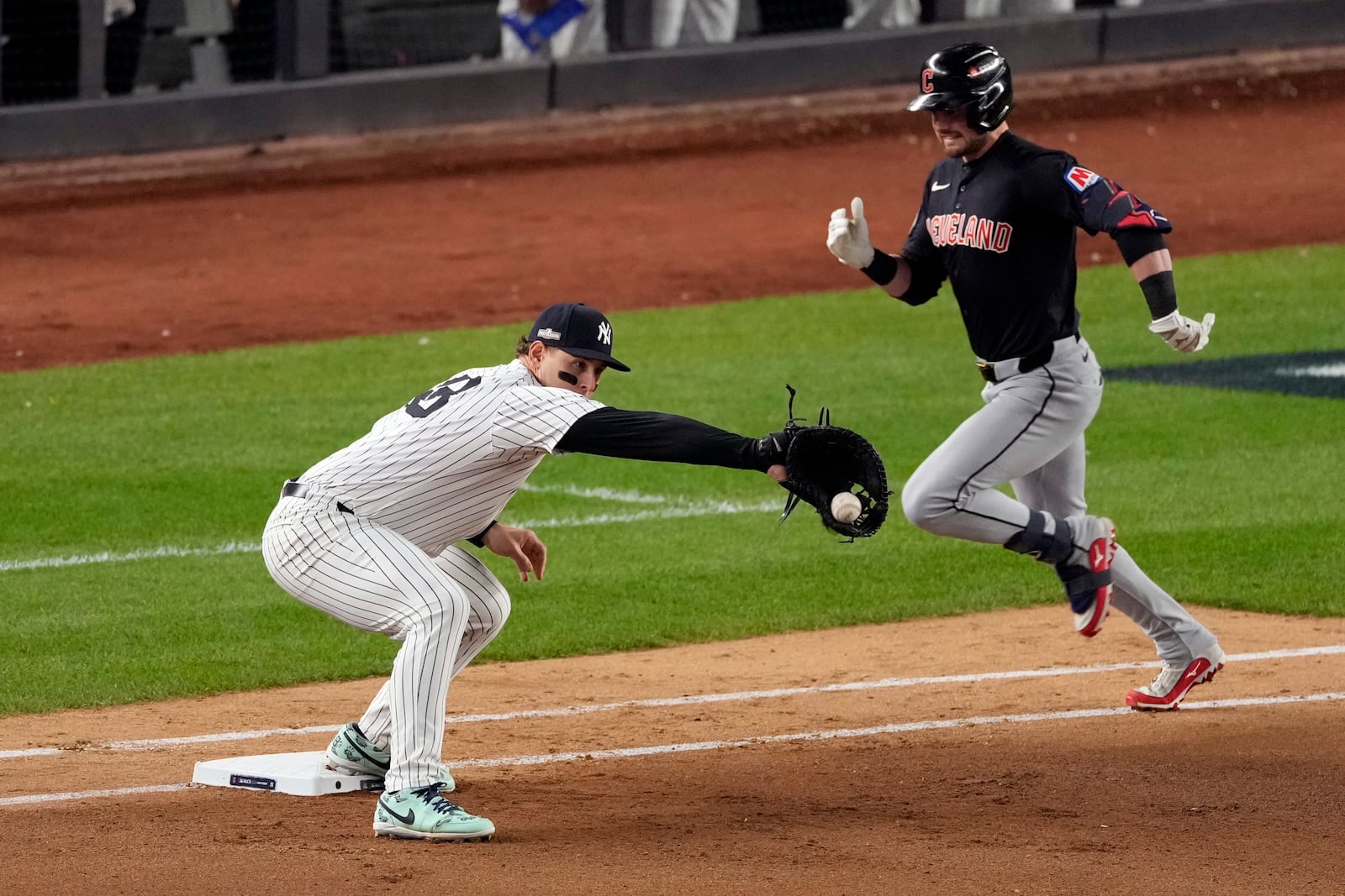 Cleveland Guardians' Lane Thomas, right, is out at first as New York Yankees first baseman Anthony Rizzo catches the throw during the seventh inning in Game 1 of the baseball AL Championship Series Monday, Oct. 14, 2024, in New York. (AP Photo/Seth Wenig)