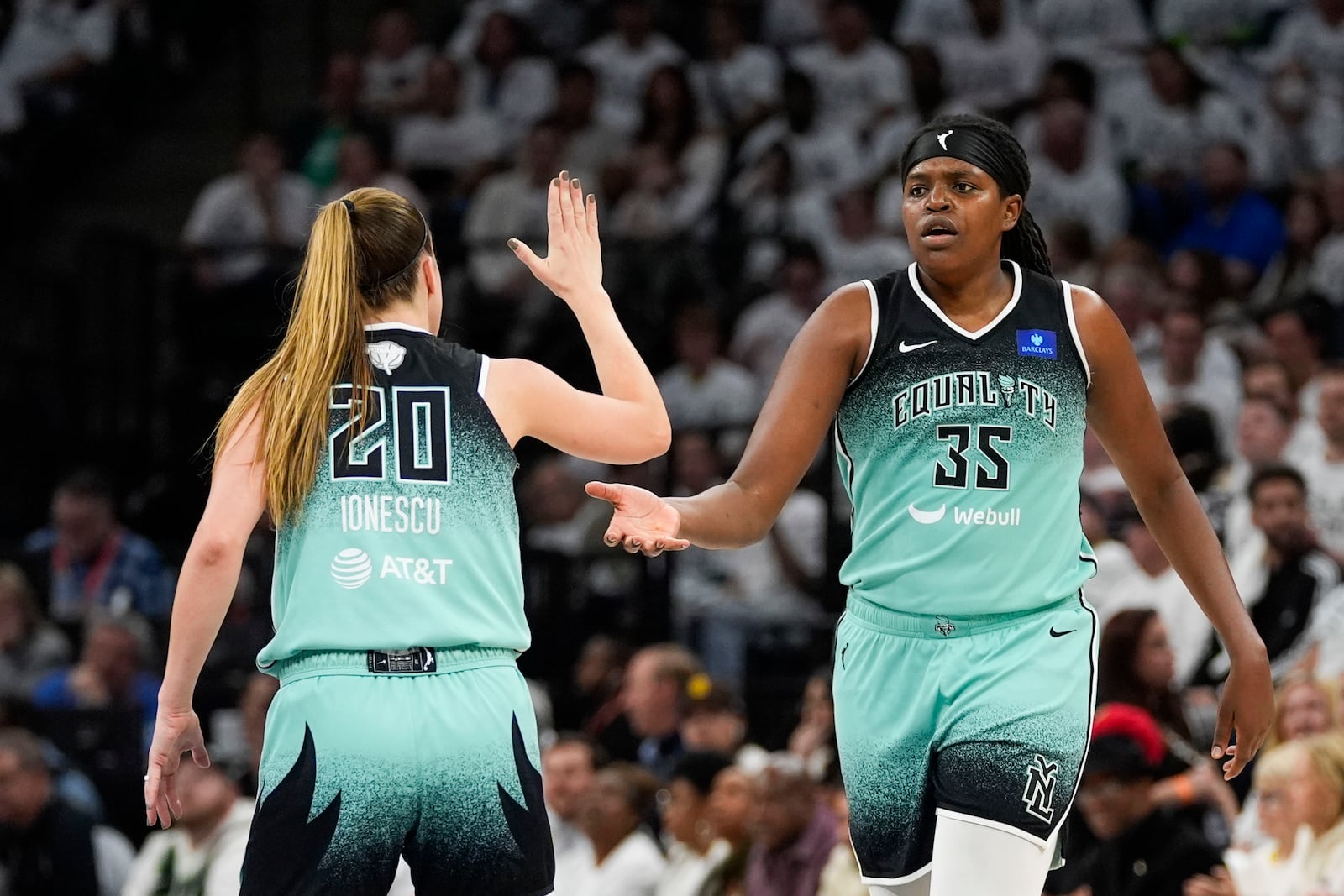 New York Liberty forward Jonquel Jones (35) celebrates her 3-point basket against the Minnesota Lynx with guard Sabrina Ionescu (20) during the second half of Game 4 of a WNBA basketball final playoff series, Friday, Oct. 18, 2024, in Minneapolis. (AP Photo/Abbie Parr)