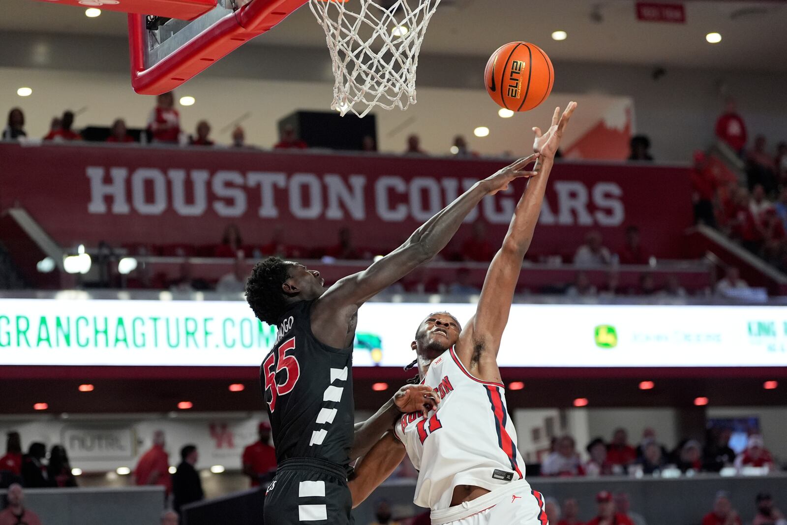 Cincinnati's Aziz Bandaogo (55) and Houston's Joseph Tugler (11) reach for a rebound during the first half of an NCAA college basketball game Saturday, March 1, 2025, in Houston. (AP Photo/David J. Phillip)