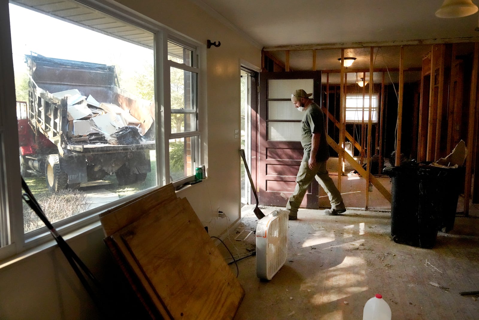 FILE - Christopher Moore walks out the front door of his home as he works to rip out its flood-damaged interior in the aftermath of Hurricane Helene, Oct. 5, 2024, in Newport, Tenn. (AP Photo/Jeff Roberson, File)