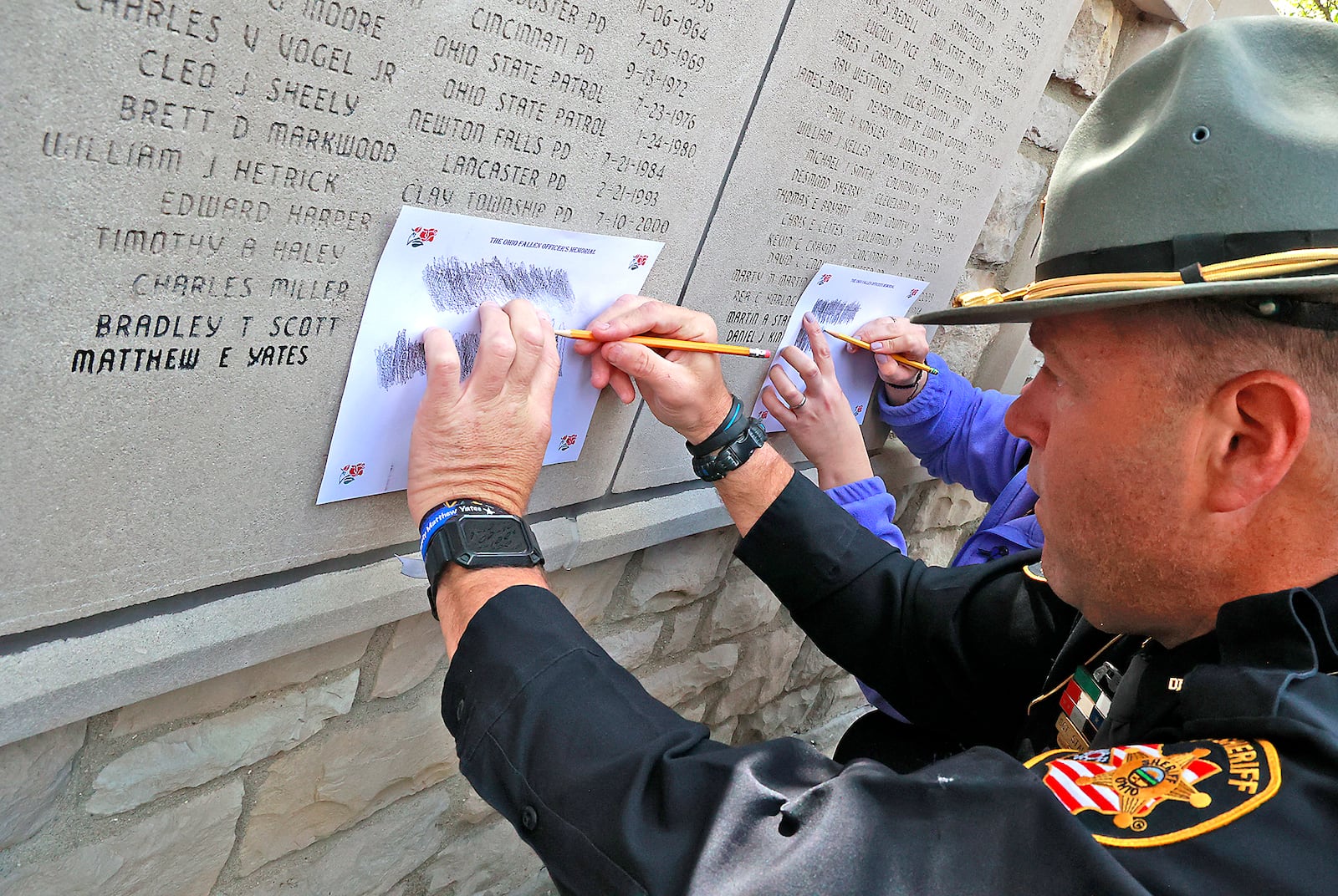 Clark County Sheriff's Sgt. Chad Stalder makes a rubbing of fallen Deputy Mathew Yates' name and date that he was killed engraved on the Ohio Fallen Officers Memorial Wall Thursday, May 4, 2023 following the Ohio Peace Officers Memorial Ceremony. BILL LACKEY/STAFF