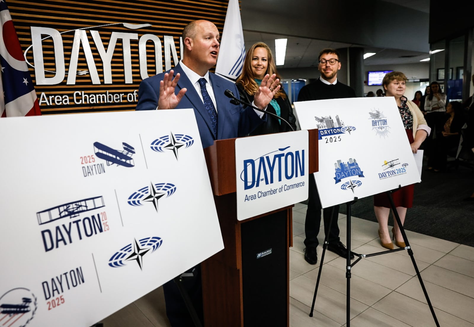 From left, President and CEO of the Dayton Area Chamber of Commerce Chris Kershner Graphic Designers Kim Swigart, Josh Trippier and Elizabeth Kimmel showoff their NATO Spring Parliamentary Assembly logos at the Dayton Area Chamber of Commerce offices on Main Street Wednesday October 9, 2024. JIM NOELKER/STAFF