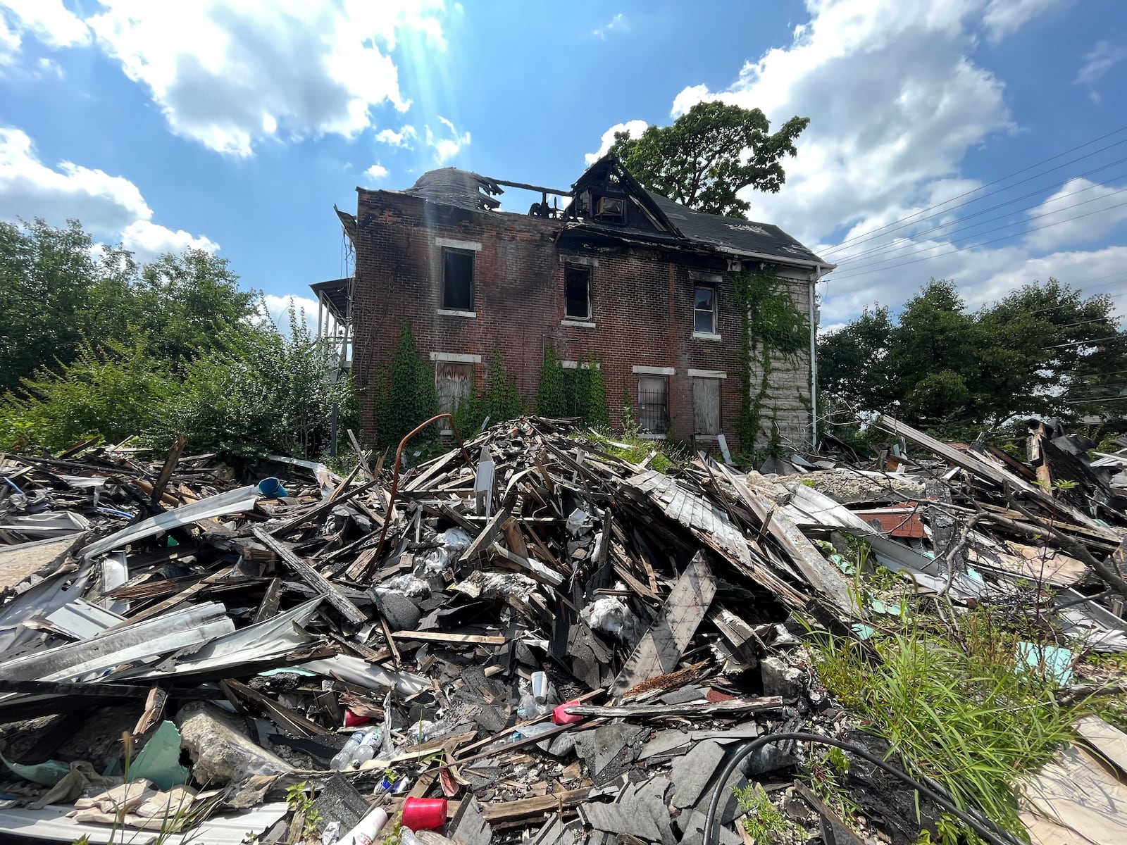 Debris and trash are still piled up on the site of a house fire on the 500 block of North Broadway Street in West Dayton. Five people were found dead after firefighters knocked down the blaze and were working at the site. CORNELIUS FROLIK / STAFF