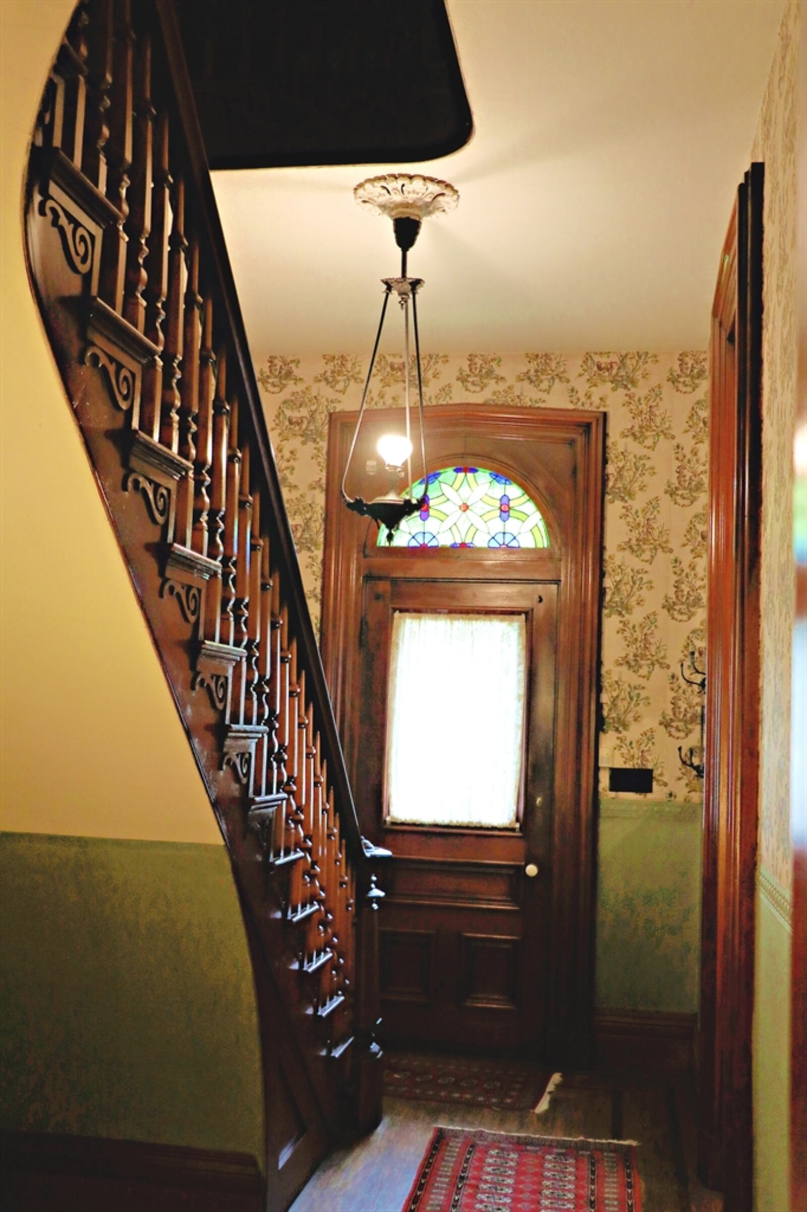 The woodwork has been maintained to its original beauty — including the ornate curved formal staircase and solid wood doors. 