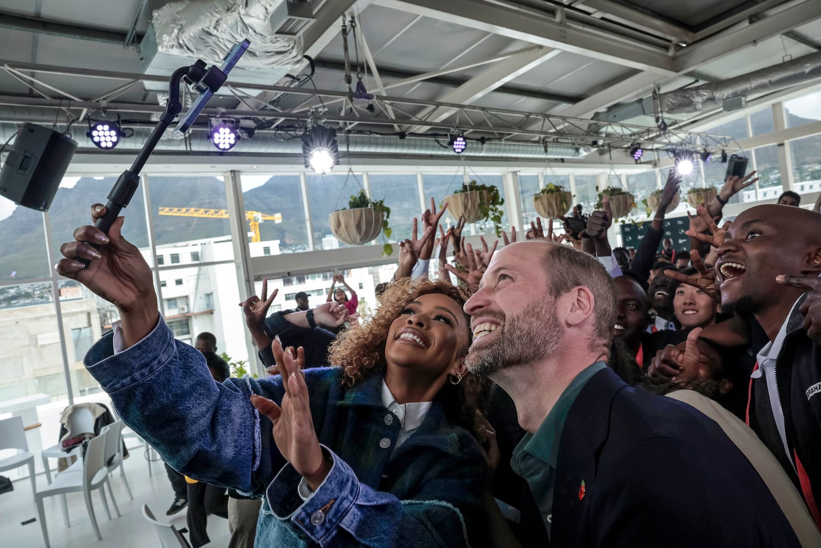 Nomzamo Mbatha, left, the host of Earthshot Week, takes a selfie with Britain's Prince William and a group of young people at the Earthshot Prize Climate Leaders Youth Programme at Rooftop on Bree in Cape Town, South Africa, Monday Nov. 4, 2024. (Gianluigi Guercia/Pool Photo via AP)