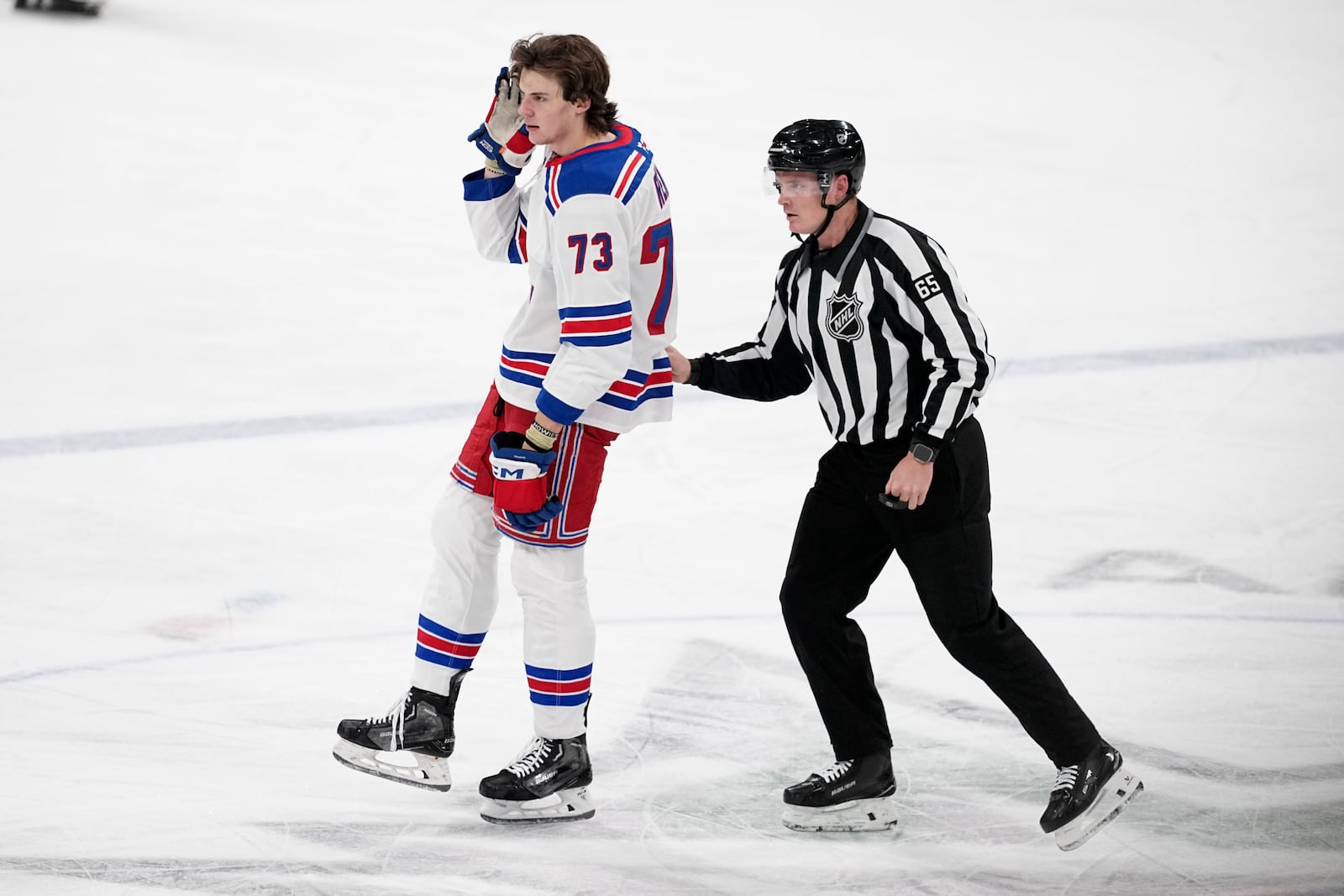 New York Rangers center Matt Rempe (73) is escorted to the penalty box by official Tommy Hughes, before being ejected for game misconduct, in the third period of an NHL hockey game against the Dallas Stars in Dallas, Friday, Dec. 20, 2024. (AP Photo/Tony Gutierrez)