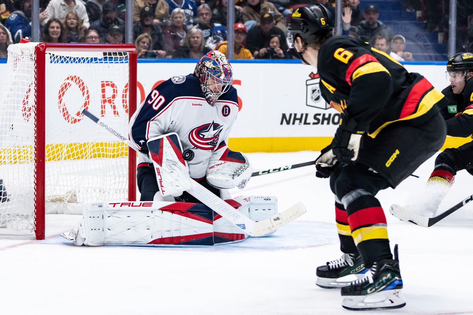 Columbus Blue Jackets goaltender Elvis Merzlikins (90) stops Vancouver Canucks' Brock Boeser (6) during the third period of an NHL hockey game in Vancouver, British Columbia, Friday, Dec. 6, 2024. (Ethan Cairns/The Canadian Press via AP)