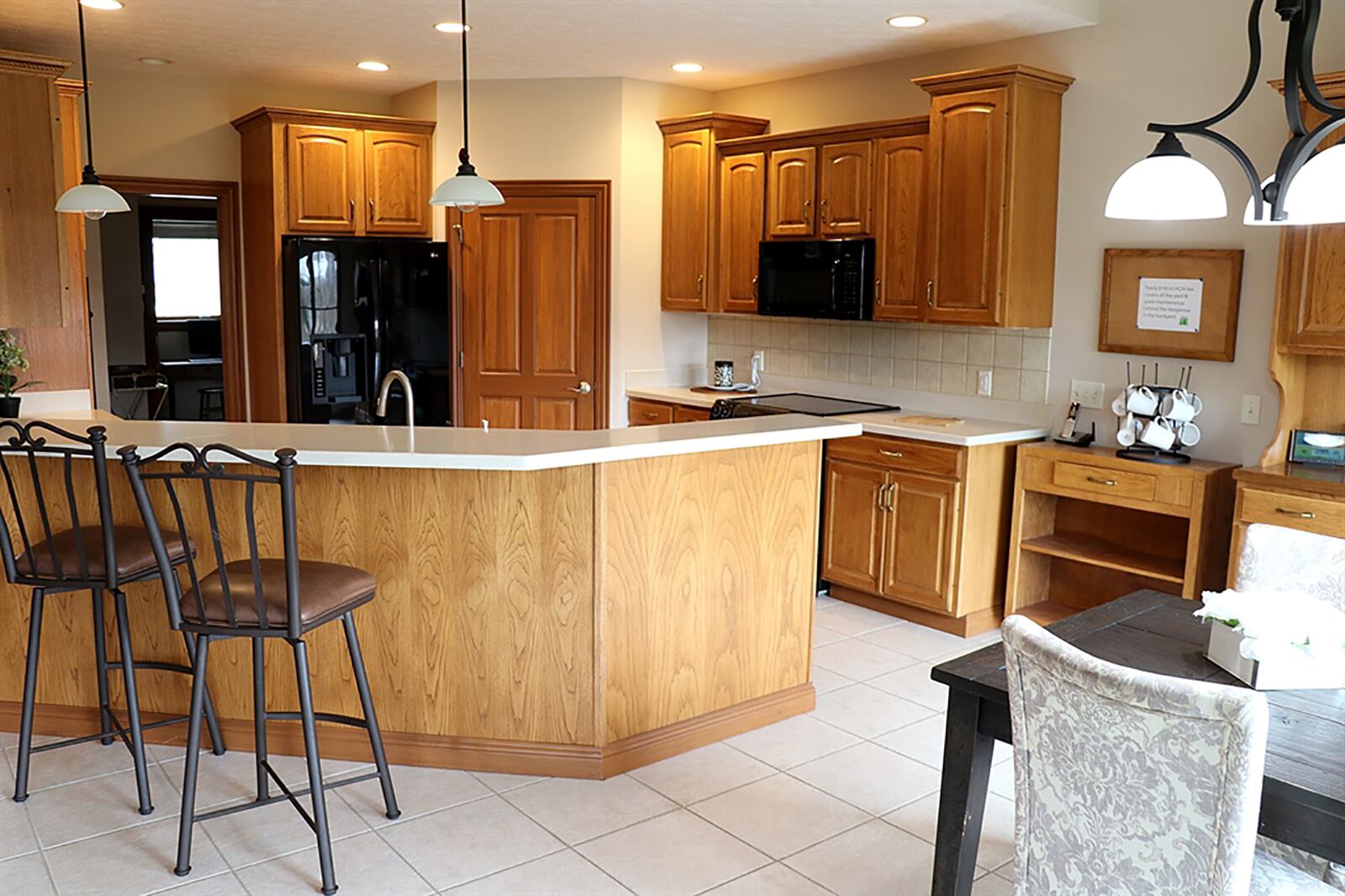 The kitchen features pecan cabinetry with Corian countertops with appliances that include a range and wall oven. The kitchen flows into the breakfast room. CONTRIBUTED PHOTO BY KATHY TYLER