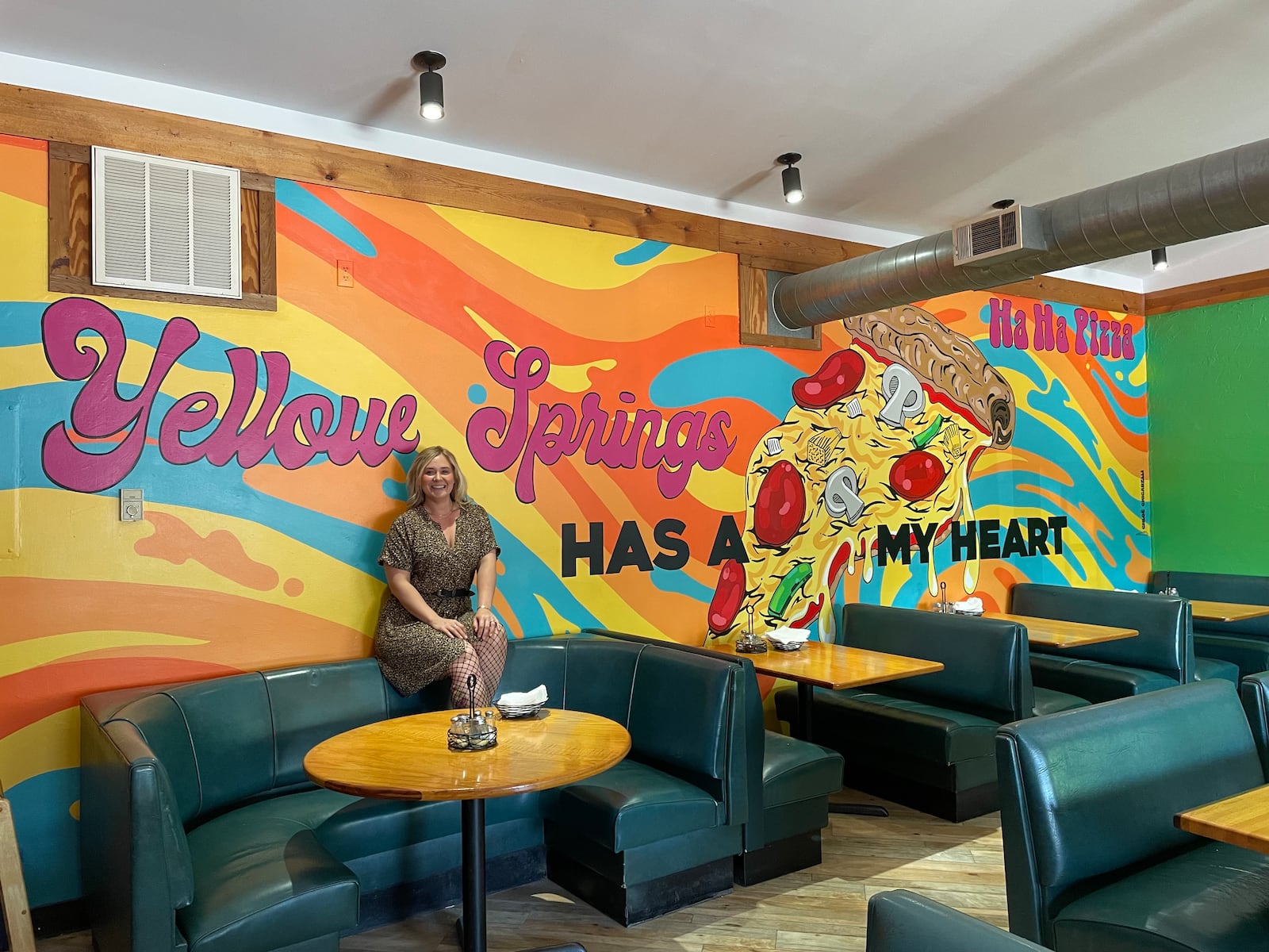 Dayton-area artist Chloé Chicarelli has put her love for Yellow Springs and Ha Ha Pizza on display through a new mural inside the pizza shop. NATALIE JONES/STAFF