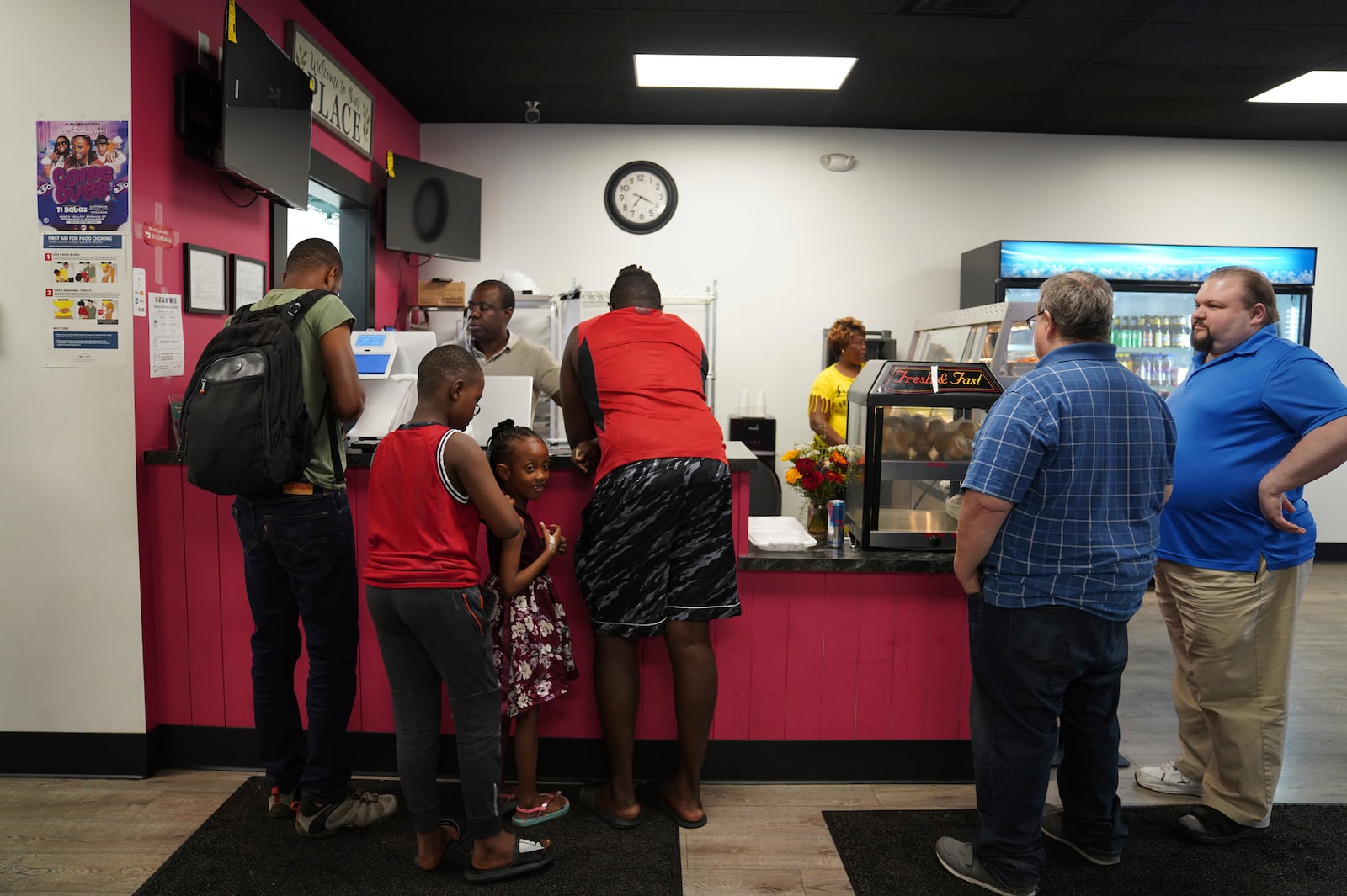 Romane Pierre of Rose Goute Creole Restaurant in Springfield, Ohio, helps a line of customers, Monday, Sept. 16, 2024. (AP Photo/Jessie Wardarski)