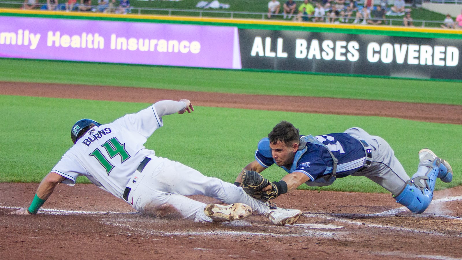 Dayton's Connor Burns is safe at home with the Dragons' first run in the third inning as West Michigan catcher Josh Crouch dives to make the tag Thursday night at Day Air Ballpark. Jeff Gilbert/CONTRIBUTED