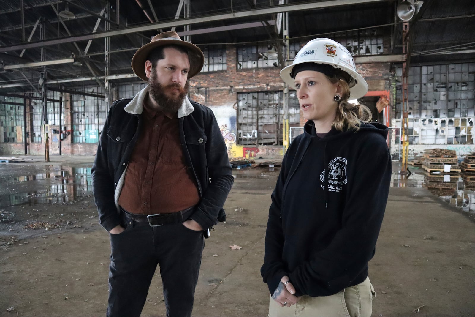 Coalfield Development CEO Jacob Hannah and Assistant Crew Chief Ashley Cain stand inside the organization’s empty Black Diamond factory construction project in Huntington, W.Va. on Thursday, Feb. 6, 2025. (AP Photo/Leah Willingham)