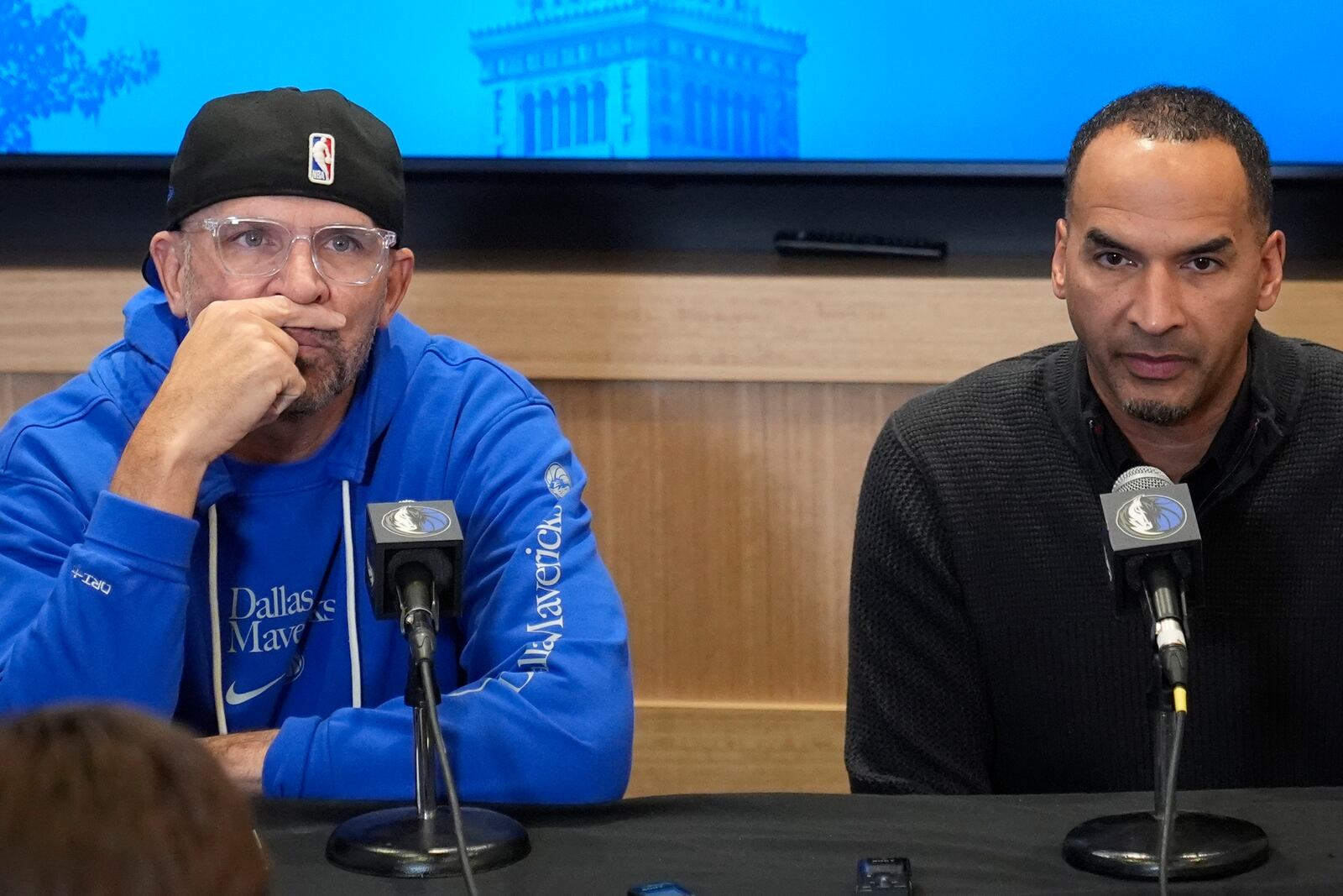 Dallas Mavericks head coach Jason Kidd, left, and general manager Nico Harrison, right, discuss the trade of Luka Doncic before an NBA basketball game against the Cleveland Cavaliers, Sunday, Feb. 2, 2025, in Cleveland. (AP Photo/Sue Ogrocki)