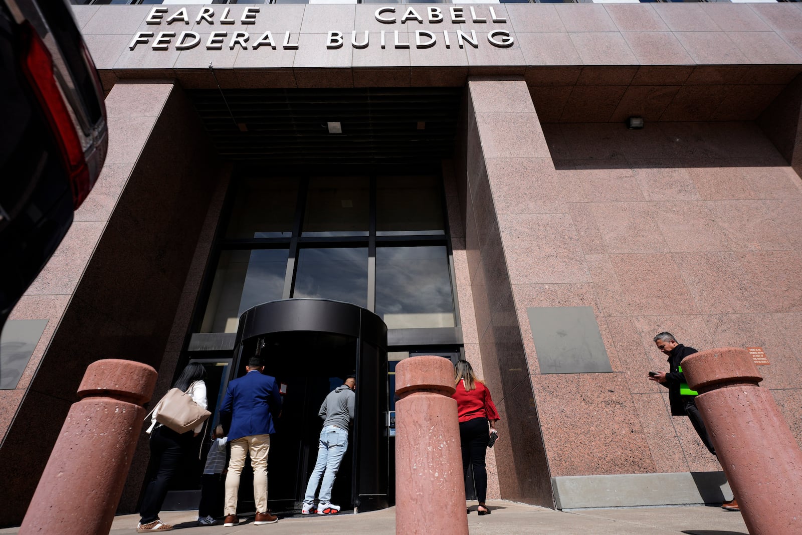 People enter the Earle Cabell Federal Building in downtown Dallas, Monday, Feb. 24, 2025. (AP Photo/LM Otero)