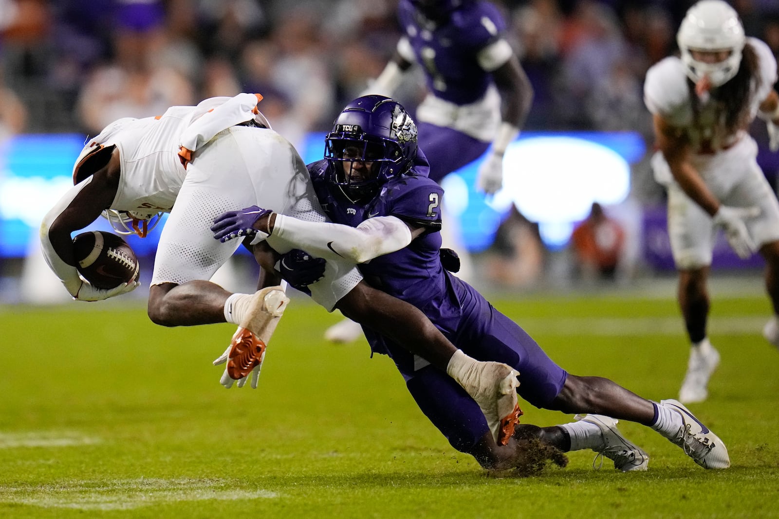 TCU cornerback Josh Newton (2) makes a tackle on Texas running back CJ Baxter during the second half of an NCAA college football game, Saturday, Nov. 11, 2023, in Fort Worth, Texas. Texas won 29-26. (AP Photo/Julio Cortez)