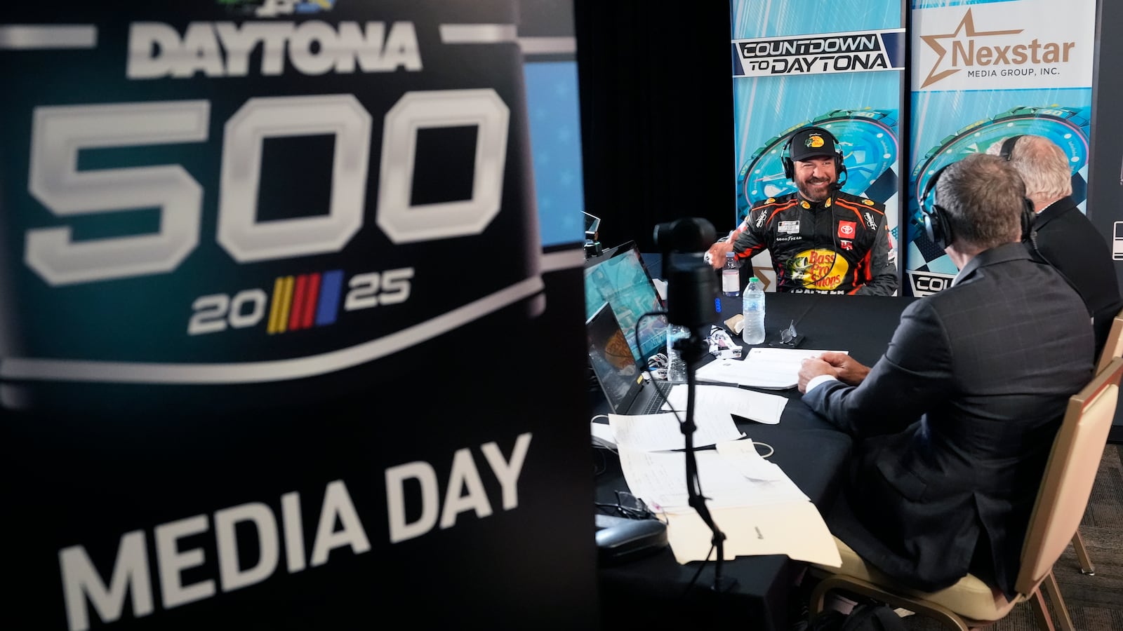 Martin Truex Jr., back center, takes part in an interview during media day at the NASCAR Daytona 500 auto race, Wednesday, Feb. 12, 2025, at Daytona International Speedway in Daytona Beach, Fla. (AP Photo/John Raoux)