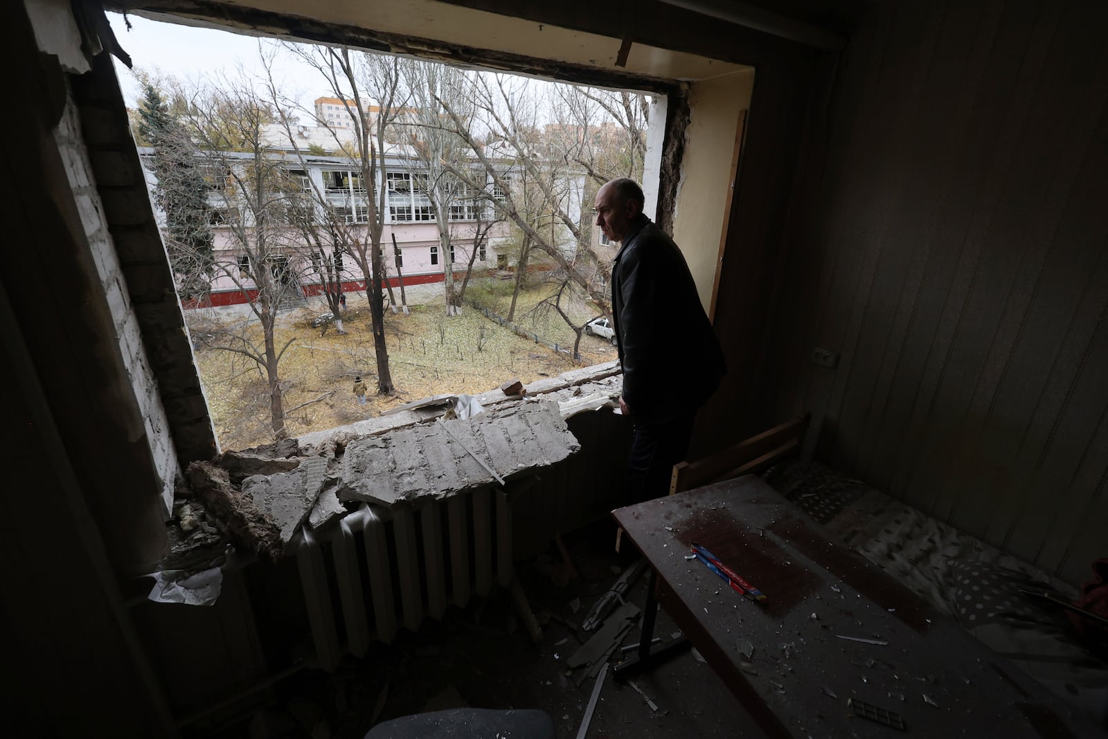 A man looks from a window of a hostel for displaced persons damaged by a Russian strike in Zaporizhzhia, Ukraine, Nov. 11, 2024. (AP Photo/Kateryna Klochko)