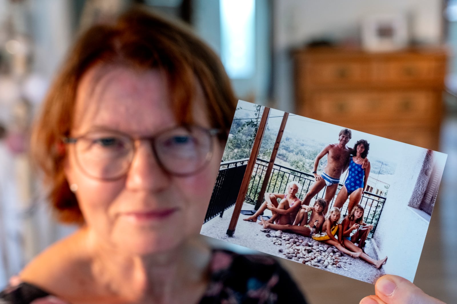 Claudia Huth shows an old photo of her family and herself in her house in Egelsbach, Germany, Thursday, Oct. 31, 2024. (AP Photo/Michael Probst)