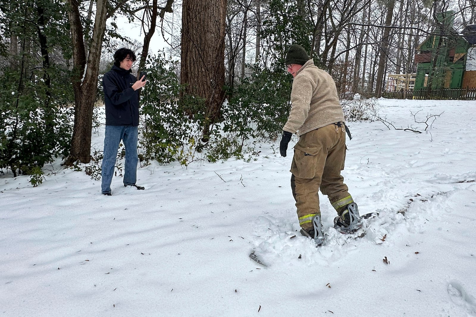 Jason Hogan, 45, takes his snowboard out for a ride as his son Jonas, 17, records it with a mobile phone after several inches of snow fell in Atlanta, Friday, Jan. 10, 2025. (AP Photo/Kate Brumback)