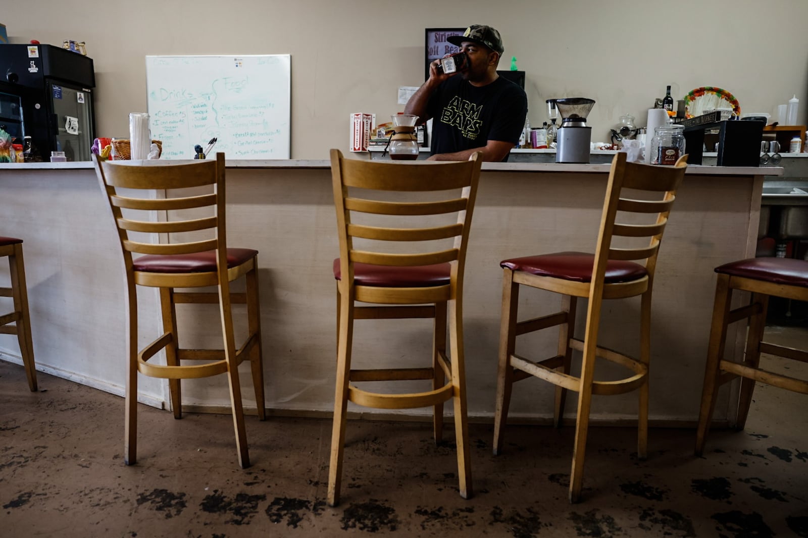 Rob Dejene owner of Nimbus Comic Cafe serves up coffee at his shop on East Main Street in Trotwood. JIM NOELKER/STAFF