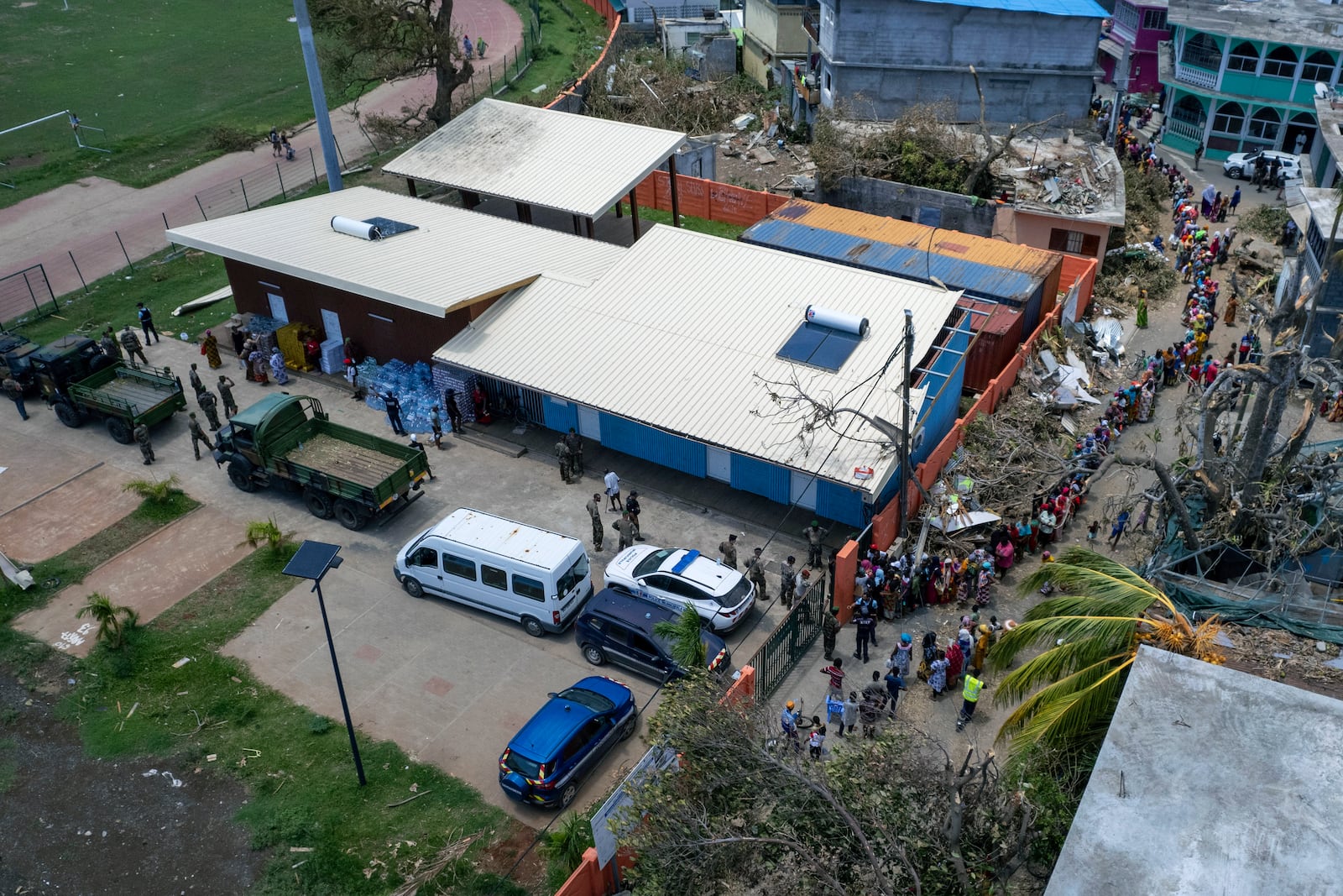 This photo provided by the French Army shows residents queu outside a military supplies center in the Indian Ocean French territory of Mayotte, Wednesday Dec.18, 2024, as the cyclone on Saturday was the deadliest storm to strike the territory in nearly a century. (D Piatacrrea, Etat Major des Armees/Legion Etrangere via AP)