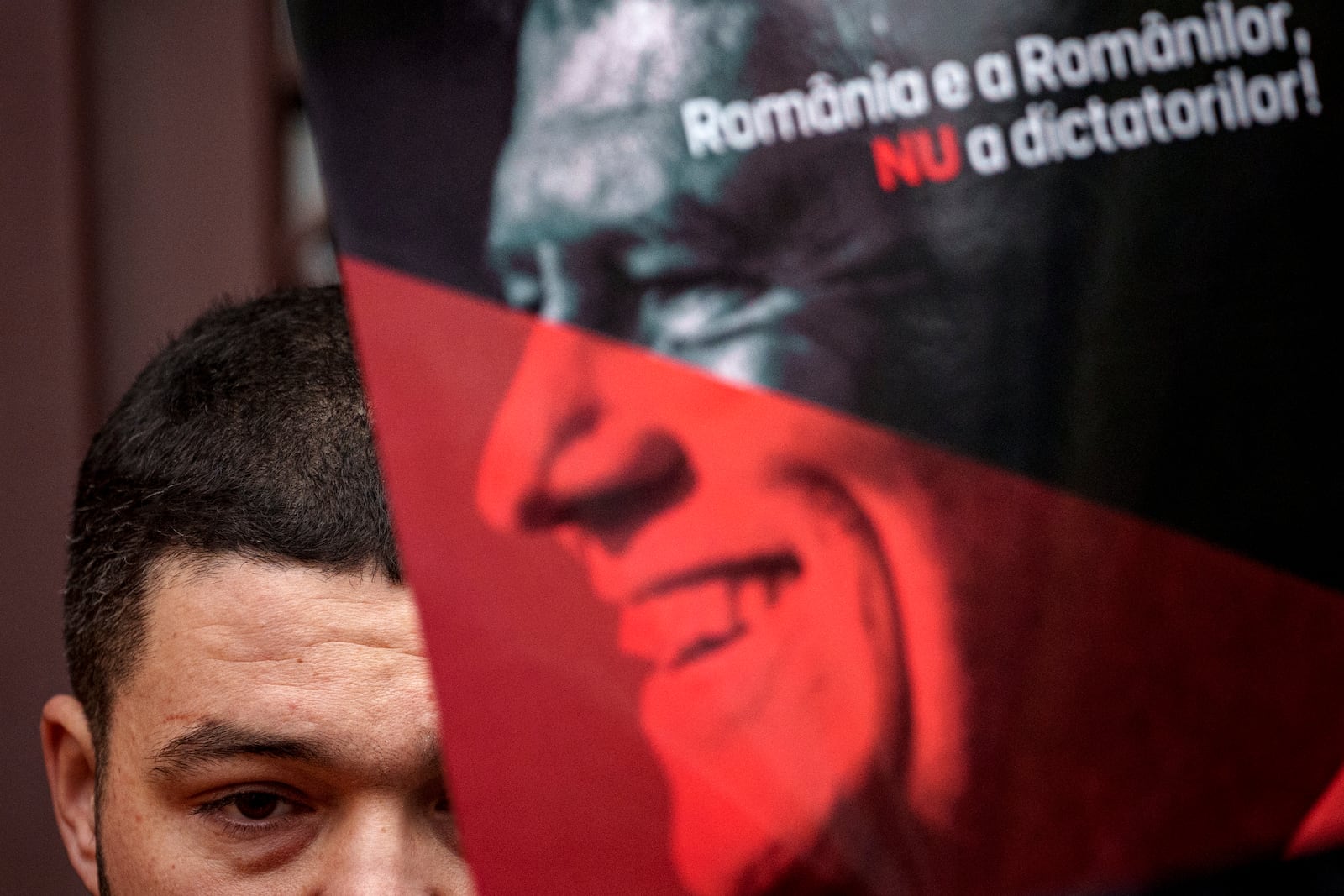 Supporters of the right wing Alliance for Unity of the Romanians (AUR) hold posters of Romania's President Klaus Iohannis reading "Iohannis Enough - Romania belongs to Romanians, not to dictators" in Bucharest, Romania, Sunday, Dec. 8, 2024. (AP Photo/Andreea Alexandru)