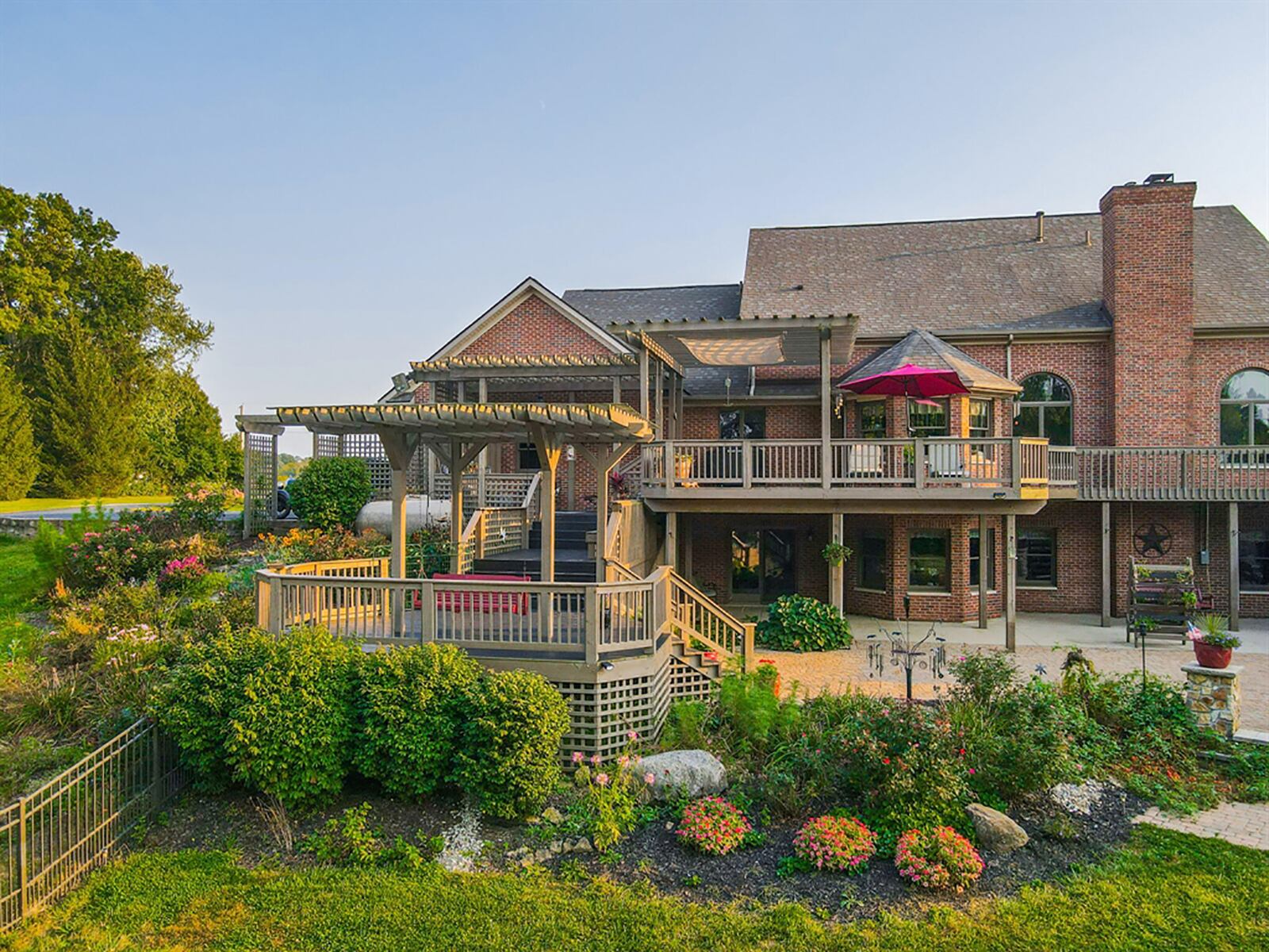 The back of the home has a variety of outdoor spaces with a wrap-around balcony deck, attached pergolas, a trellis with a swing, paver-brick sun patios with matching outdoor fireplace and covered concrete patios. Tailored landscaping surrounds the patios and a wrought iron fence surrounds part of the yard. CONTRIBUTED PHOTO