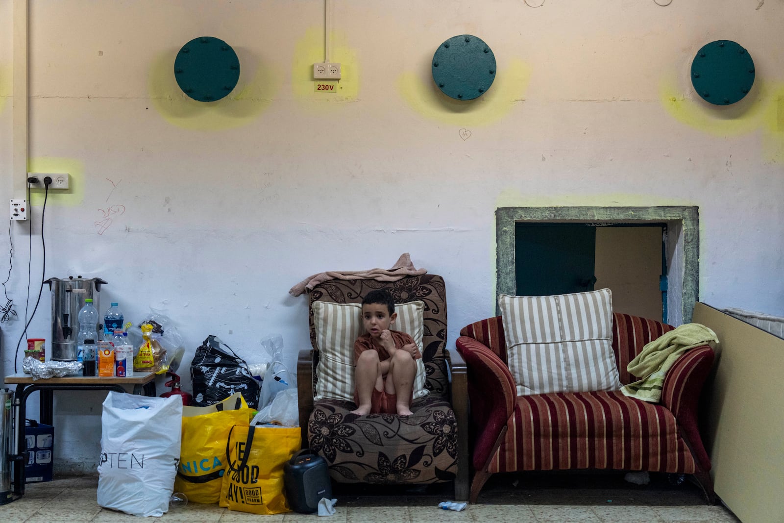 A boy sits in a public bomb shelter to be safe from rockets fired from Lebanon in Acre, northern Israel, Sunday, Oct. 13, 2024. (AP Photo/Ariel Schalit)