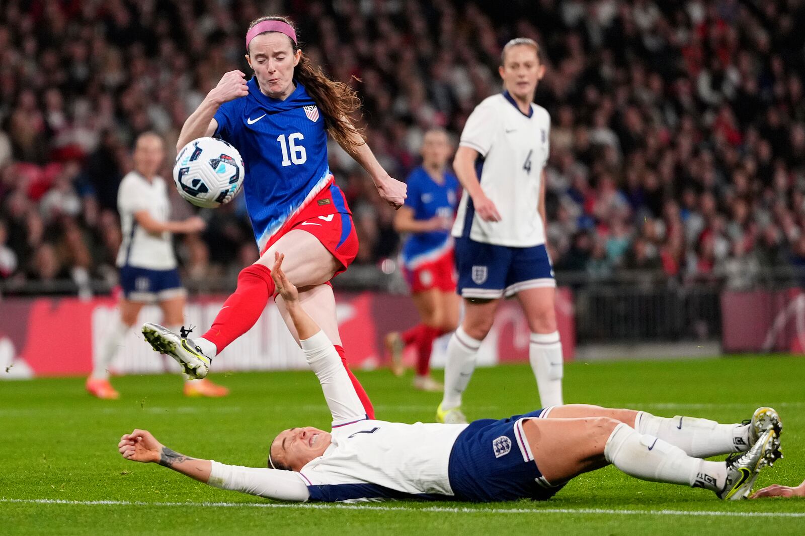 United States' Rose Lavelle, left, and England's Lucy Bronze challenge for the ball during the International friendly women soccer match between England and United States at Wembley stadium in London, Saturday, Nov. 30, 2024. (AP Photo/Kirsty Wigglesworth)