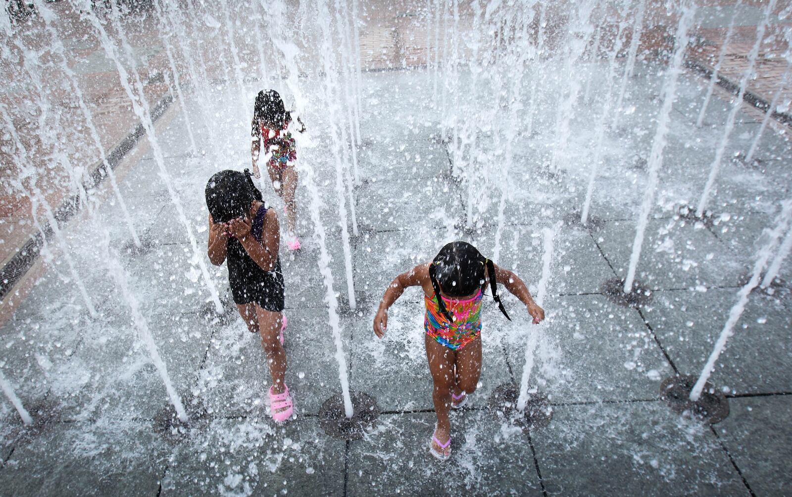 Children walk through the fountains on Riverscape to beat the heat Wednesday. A heat advisory from the National Weather Service is set for noon to 8 p.m. today. Highs will be in the low-90s, but the extreme humidity will push the heat index up. The real feel temperature is 100 degrees. JIM WITMER / STAFF