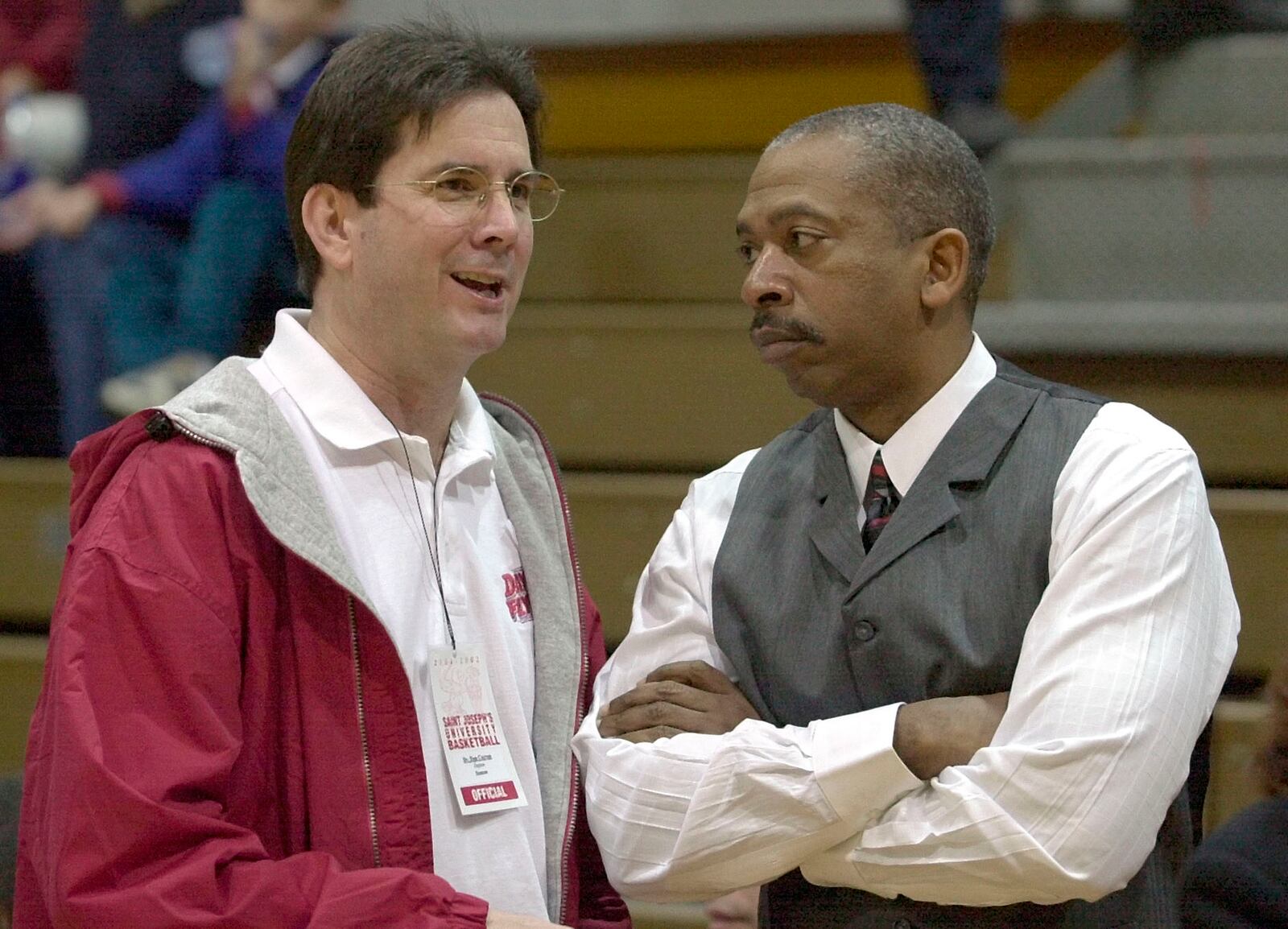 SPECIAL FOR THE DAYTON DAILY NEWS--New University of Dayton President Daniel J. Curran, left, talks with Dayton head basketball coach Oliver Purnell, right, before the start of their game agaisnt St. Joseph's University in Philadelphia Saturday, Feb. 23, 2002.(AP Photo/Chris Gardner)