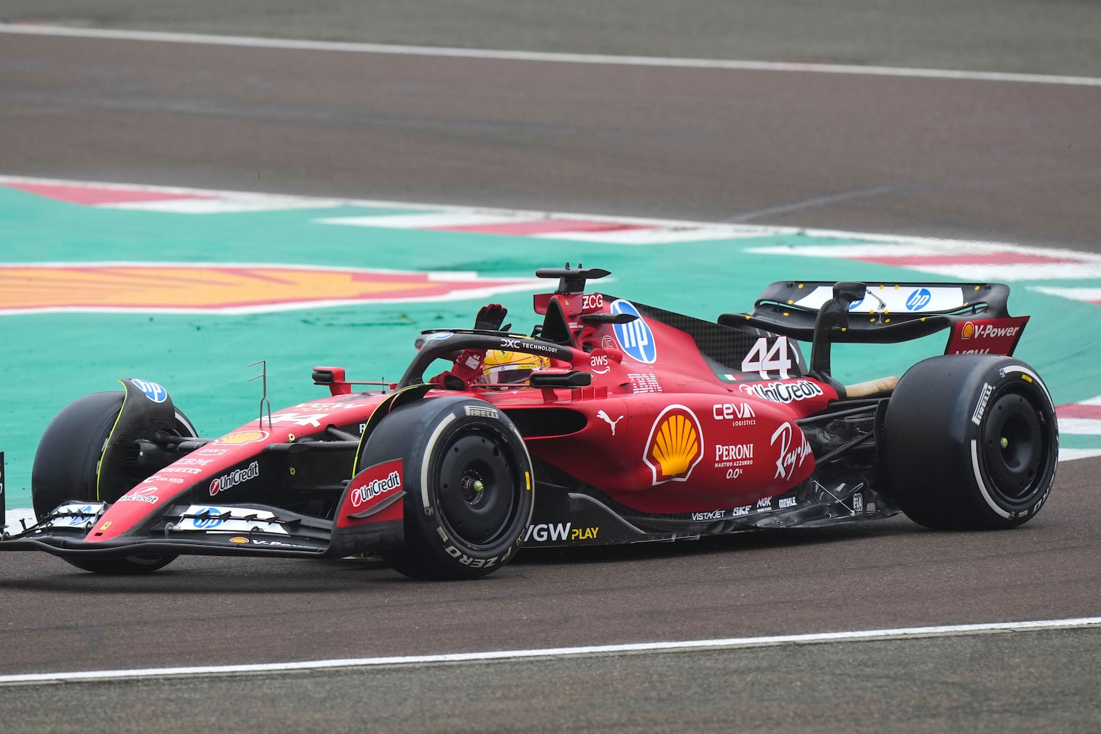 British driver Lewis Hamilton waves to fans as he steers a Ferrari Formula One SF-23 at the Ferrari private test track, in Fiorano Modenese, Italy, Wednesday, Jan.22, 2025. (AP Photo/Luca Bruno)